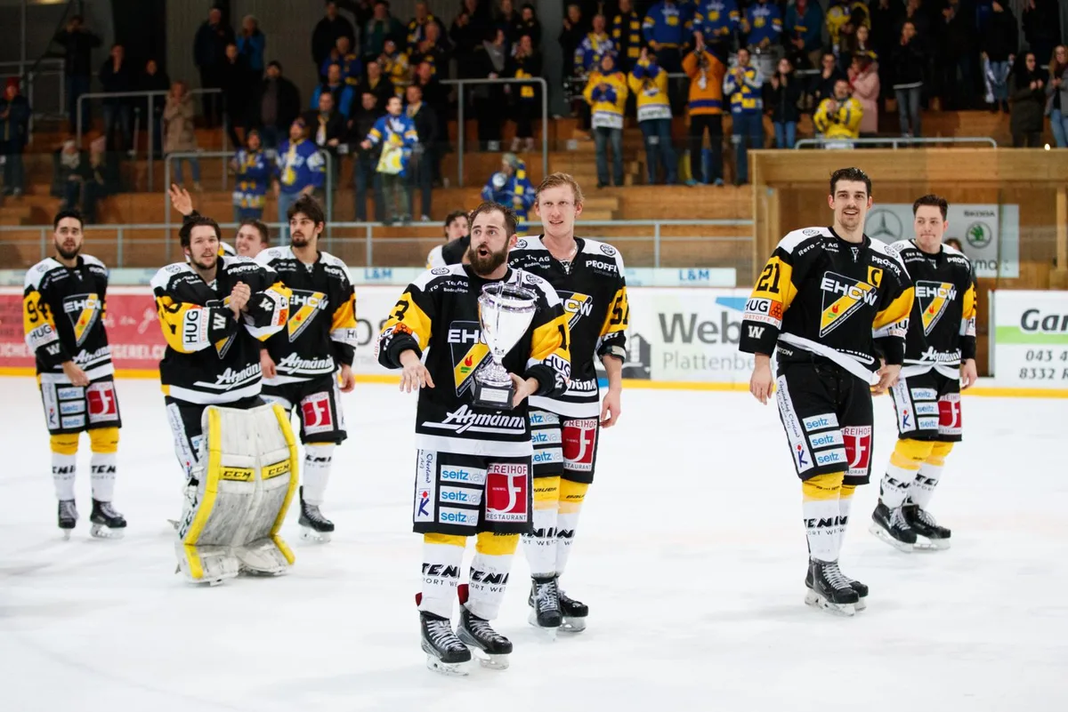 Von den Fans gefeiert: Peter Hürlimann (vorne) und seine Teamkollegen auf der Ehrenrunde. (Foto: David Kündig), Der Captain geht voraus: Nicolas Marzan und seine siegreichen Wetziker Jungs. (Foto: David Kündig), EHCW-Captain Nicolas Marzan mit dem Pokal. (Foto: David Kündig), Der Moment des Triumphes: Handschuhe und Stöcke fliegen durch die Luft. Und Torhüter Odin Neuenschwander erhält sehr viel Besuch. (Foto: David Kündig), Freude herrscht bei den Wetzikern. (Foto: David Kündig)
