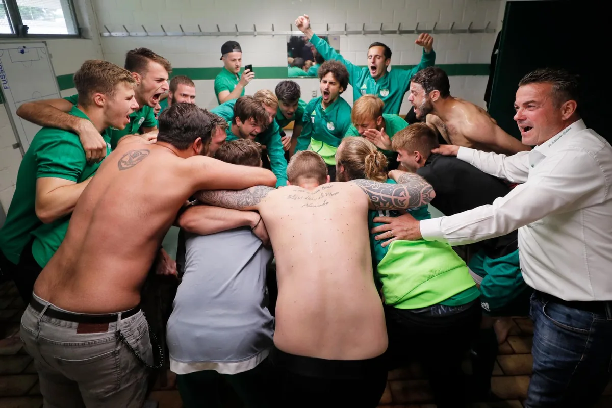 d1_preview Und jetzt alle miteinander: Die Brüttiseller Spieler und Trainer Robert Merlo lassen es in der Kabine krachen. (Foto: Sibylle Meier), Aufstiegsjubel in der Kabine: Brüttisellen-Dietlikon-Trainer Robert Merlo feiert mit seinen Spielern die Rückkehr in die 2. Liga. (Foto: Sibylle Meier)