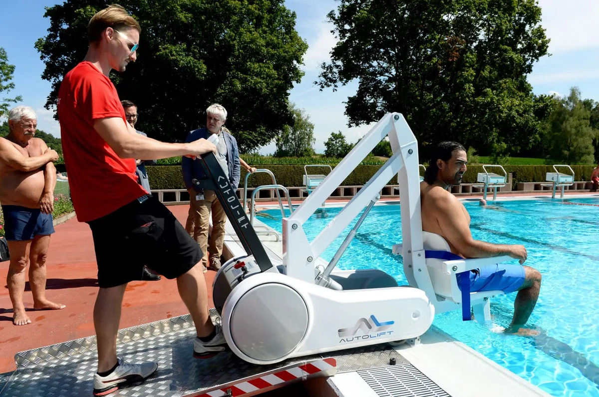 uster_barrierefreiheitbadivolketswil_14-07-2018_tz_mav_5_preview In der Badi Volketswil können Menschen mit einer körperlichen Beeinträchtigung ab sofort eine auf deren Bedürfnisse eingerichtete Garderobe nutzen. Zudem steht eine Hebevorrichtung zur Verfügung, die den Einstieg ins Schwimmbecken erleichtert. (Foto: Marcel Vollenweider), In der Badi Volketswil können Menschen mit einer körperlichen Beeinträchtigung ab sofort eine auf deren Bedürfnisse eingerichtete Garderobe nutzen. Zudem steht eine Hebevorrichtung zur Verfügung, die den Einstieg ins Schwimmbecken erleichtert. (Foto: Marcel Vollenweider), In der Badi Volketswil können Menschen mit einer körperlichen Beeinträchtigung ab sofort eine auf deren Bedürfnisse eingerichtete Garderobe nutzen. Zudem steht eine Hebevorrichtung zur Verfügung, die den Einstieg ins Schwimmbecken erleichtert. (Foto: Marcel Vollenweider), Gemeinderat Michael De Vita-Läubli, Uwe Betz-Moser (Leiter Liegenschaften Volketswil), René Läuchli (Leiter des Schwimmbades Waldacher) und Bruno Sieber (Beck Schwimmbad Bau) begutachten die neue Kabine (von links). (Foto: Marcel Vollenweider), In der Badi Volketswil können Menschen mit einer körperlichen Beeinträchtigung ab sofort eine auf deren Bedürfnisse eingerichtete Garderobe nutzen. Zudem steht eine Hebevorrichtung zur Verfügung, die den Einstieg ins Schwimmbecken erleichtert. (Foto: Marcel Vollenweider)