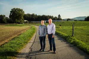 https-zueriost-ch-sites-default-files-elvis-media-2018-09-gutenswil_20092018_gestank_sbo_2_preview-jpg Blick auf Biogasanlage und Schweinemast: Ivano Celia (links) und Albert von Rohr machen mobil für mehr Lebensqualität., Nicht nur die Gutenswiler Anwohner, auch Gemeinde, Kanton und Betreiber gehen davon aus, dass die Anlage für den Gestank sorgt.