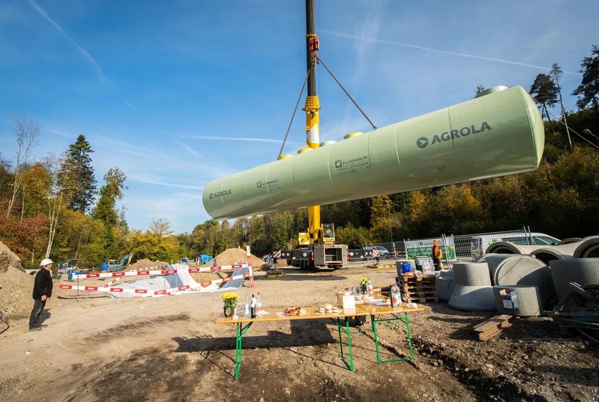 illnau_16102018_tankversenkung_sbo_5_preview An der Kempttalstrasse in Illnau wird eine neue Agrola Tankstelle gebaut. , Marc Messerli (r.) klärte die Zuschauer über das Projekt auf. , Im Rahmen der Bauarbeiten wurde heute ein 25-Tonnen-Tank in den Boden versenkt. , Der Tank hat ein Fassungsvermögen von 120'000 Liter. , Vor der Versenkung wurde er auf allfällige Schäden überprüft.