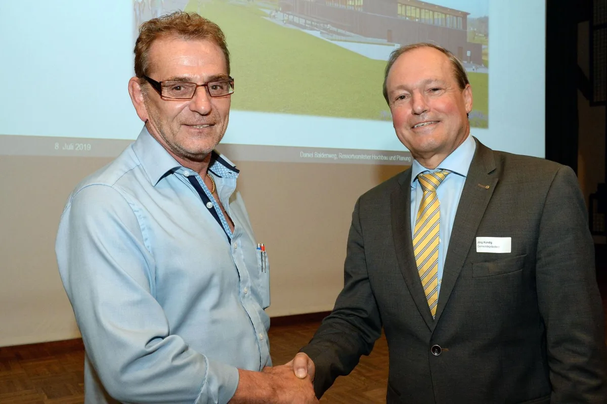 hinwil_sporthalleinvestorandileutenegger_gossau_10-07-2019_tz_mav_1_preview Andreas Leutenegger (links) will der Gemeinde Gossau eine Dreifachturnhalle schenken., Neben dem Schulhaus Berg an der Altrütistrasse soll die Halle zu liegen kommen., Eine Aussenansicht der Halle., Im Innern sind drei Hallenfelder und eine grosse Tribüne geplant., Der Grundriss der Halle., Ein Blick in den Foyerbereich., Und eine weitere Aussenansicht der Halle.