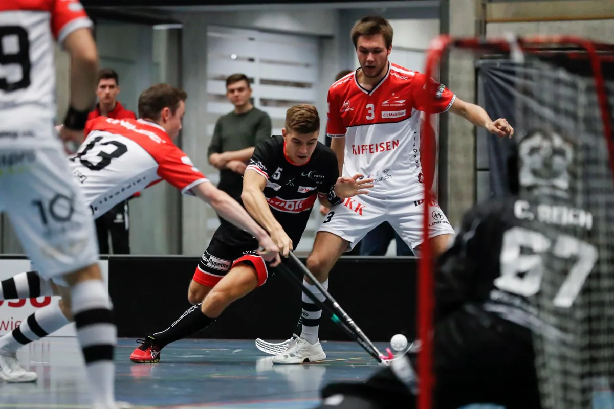 sport_12102019_unihockey_crm_03_preview Einer mit dem Arm, einer mit dem Bein: Der Ustermer Remo Gallati wird gleich von zwei Chur-Spielern behindert.