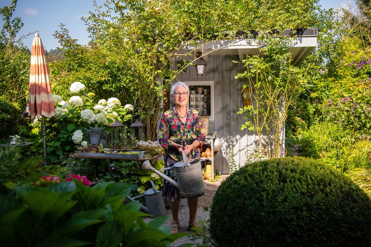 Isolde Hensgen in ihrem Garten in Bauma. , In ihrem «Gärtli» gibt es für sie immer viel zu tun. , Der Duft der Blumen schlägt einem beim Betreten des Gartes gleich entgegen. , Unter der Tessiner Pergola geniessen Isolde Hensgen und ihr Mann regelmässig am Sonntag ihren Zmorge., Im Biotop hatte es einst Fische – doch diese hat der Reiher alle geholt.
