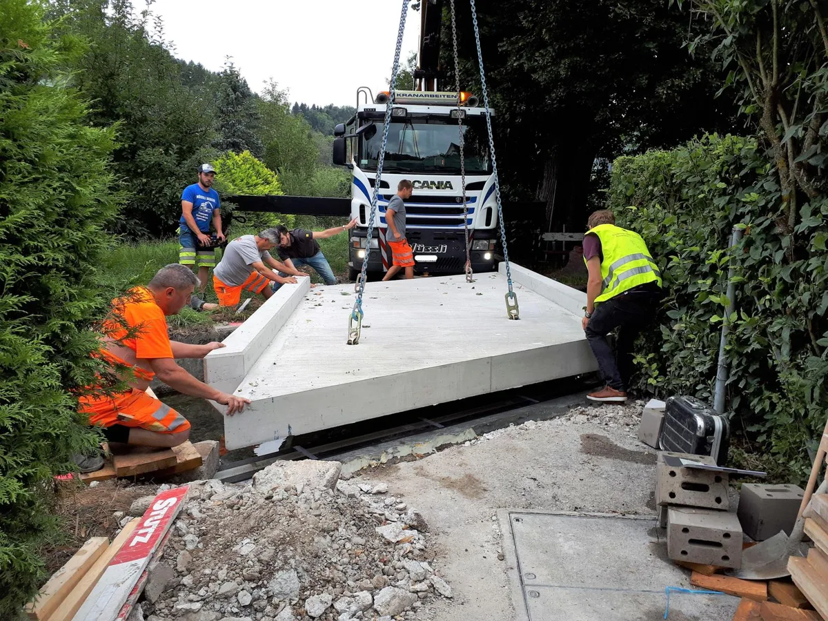 bruecke3_li_preview Am Dienstagmorgen wurde die neue Brücke geliefert und eingesetzt., Die Brücke wiegt zwölf Tonnen und wurde mit dem Kran angehoben., Die richtige Position zu finden war keine einfache Aufgabe., Etwa eine Stunde dauerte das Prozedere. Nun steht die Brücke., So sah es vorher aus: Die alte Brücke war sanierungsbedürftig., Die Ruhe vor dem Sturm, bevor die Brücke geliefert wird. , Für die Verpflegung der Bauarbeiter ist gesorgt.