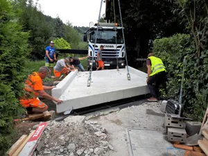 bruecke3_li_preview Am Dienstagmorgen wurde die neue Brücke geliefert und eingesetzt., Die Brücke wiegt zwölf Tonnen und wurde mit dem Kran angehoben., Die richtige Position zu finden war keine einfache Aufgabe., Etwa eine Stunde dauerte das Prozedere. Nun steht die Brücke., So sah es vorher aus: Die alte Brücke war sanierungsbedürftig., Die Ruhe vor dem Sturm, bevor die Brücke geliefert wird. , Für die Verpflegung der Bauarbeiter ist gesorgt.