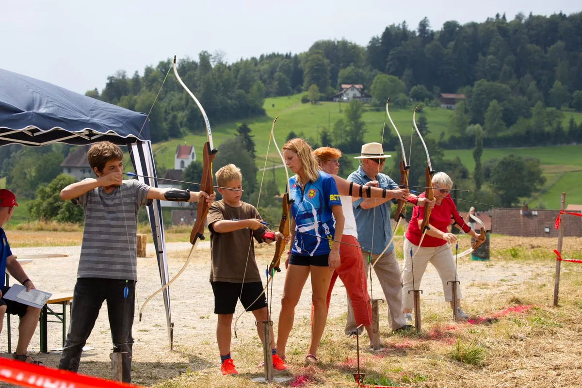 An der Bundesfeier stellten die Schlattemerinnen und Schlattemer ihre Fertigkeiten im Bogenschiessen unter Beweis., Angeleitet wurden sie dabei von Mitgliedern des Bogenclubs Thurland., Denn gut zielen …, … und gut treffen will geübt sein., Teilnehmen durfte jede und jeder., Unermüdlich wurde um die Wette geschossen …, … bis schliesslich die drei besten Schützen auserkoren waren., Die Bundesfeier organisierten die Mitglieder des Bogenclubs Thurland., Nach der Rangverkündigung stand gemütliches Beisammensein auf dem Programm., Dank dem schönen Wetter liess es sich auf den Festbänken gut aushalten., Das Fest sorgte für Freude bei den Gästen., Trotz der Feierlaune durften die Corona-Schutzmassnahmen nicht vergessen werden., Die kleinen Gäste freuten sich darauf, endlich das Feuerwerk zu zünden., Natürlich ausgerüstet mit Gehörschutz., Das Fest sorgte für Freude bei den Gästen., Das Fest sorgte für Freude bei den Gästen., Das Fest sorgte für Freude bei den Gästen., Das Fest sorgte für Freude bei den Gästen., Das Fest sorgte für Freude bei den Gästen.