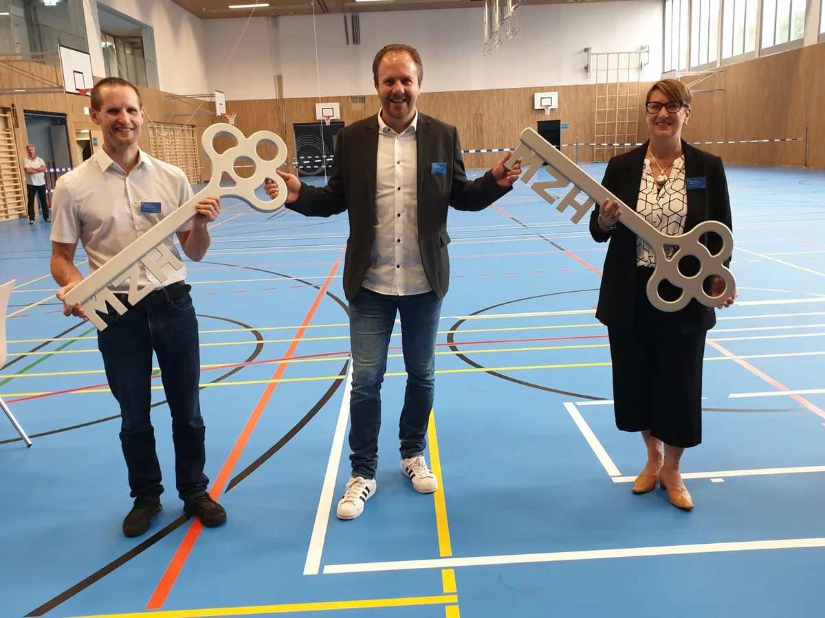 2020_schl%c3%bcssel%c3%bcbergabe%20aussergass_pd_preview Gemeindepräsident Carlo Wiedmer (Mitte) kann die neue Mehrzweckhalle einweihen., Innert rund zwei Jahres ist die Mehrzweckhalle Aussergass erstellt worden., Das Bauwerk hat 17 Millionen Franken gekostet.