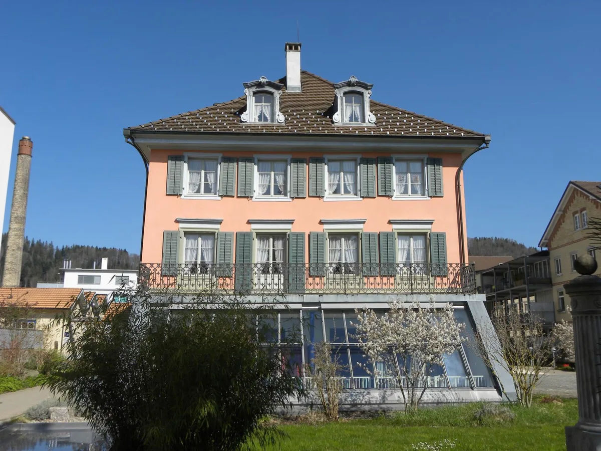 050521_rosa_villa_turbenthal_4_rg_preview Inmitten einer würdigen Umgebung steht die Rosa Villa im Zentrum von Turbenthal., Diese Aufnahme von Carl Spahr zeigt, wie gut man einst die Villa und ihren prächtigen Garten aus der Luft erkennen konnte., Als Zeuge der Baumwollspinnerei Wolf ragt noch heute der Hochkamin aus dem Jahr 1887 in den Himmel.