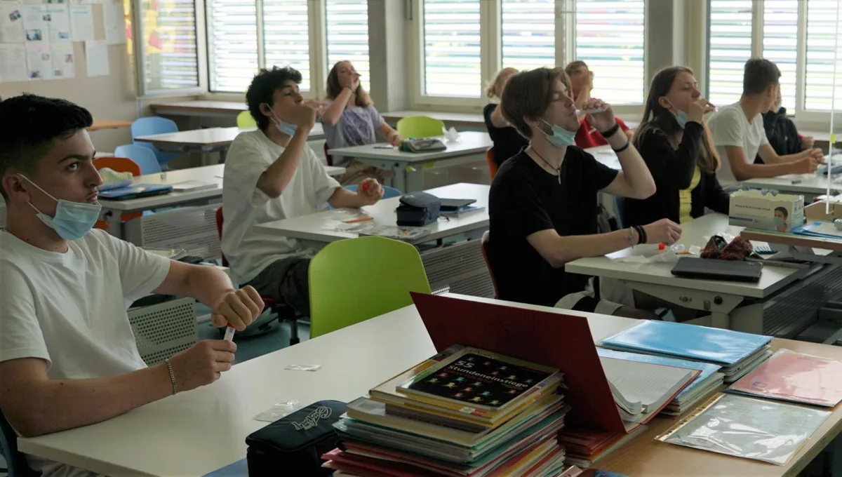 140621_spucktests_gaeh_6_preview In der Sekundarschule Turbenthal-Wildberg werden jeweils am Montag freiwillige Corona-Tests durchgeführt., Dafür erhalten die Schülerinnen und Schüler ein Teströhrchen inklusive Aufklebeetikett., Zuerst wird das Röhrchen beschriftet., Danach spülen die Jugendlichen und Klassenlehrer René Hüsli eine Kochsalzlösung eine Minute lang im Mund., Anschliessend spucken sie in das Teströhrchen., Dieses wird kräftig geschüttelt …, … und zum Schluss gut verpackt., Jede Klasse sammelt die Tests in einer Box., Die Boxen werden während der Pause auf einen Wagen gestellt und vom Hausdienst abgeholt.