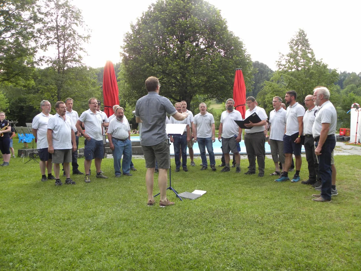 180621_bichelsee_singen_2_preview Der Männerchor Neubrunn wagte mit dem Konzert am Bichelsee den Schritt in die Normalität., Dirigent Daniel Stamm macht gutgelaunt die Liedankündigung für das Publikum.
