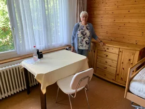 230621_umzug%20rosenthal_19_cb_preview Viel Holz hat es in Colette Kuratlis altem Zimmer im Altersheim gehabt., Abschied nehmen vom Balkönli: Von hier konnte Colette Kuratli im «Drei Tannen» Tiere beobachten. , Zusammen mit einer Betreuerin kehrt Colette Kuratli dem «Drei Tannen» den Rücken., In einem Car geht es auf Umwegen zu ihrem neuen Daheim im Dorf unten., Während die Seniorinnen und Senioren auf Ausfahrt gehen, werden ihre Möbel ins Alterszentrum Rosenthal transportiert. , Angekommen in ihrem neuen Zuhause, dem Alterszentrum Rosenthal., Colette Kuratli freut sich auf ihr neues Zimmer., Im vierten Stock werden die neuen Bewohner vom Personal in Empfang genommen., Das neue Zimmer von Colette Kurtali ist bereit zum Bezug., Das Essen wird im Rosenthal jeweils in der Gruppe eingenommen., Viel Licht und einen weiten Ausblick bietet das neue Zimmer., Die katholische Kirche beherrscht den Ausblick von Colette Kuratlis Zimmer aus., Den ganzen Tag über werden die Möbel und Gepäckstücke der neuen Bewohner auf die Zimmer verteilt., Käthi Schmidt (links), Vizepräsidentin der Stiftung Drei Tannen, besucht Colette Kuratli in ihrem neuen Zuhause.