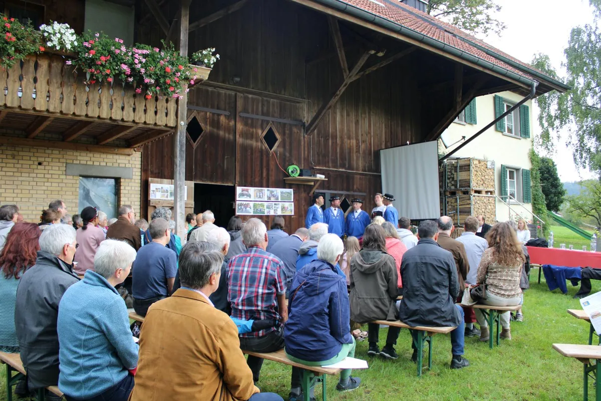 210926_erntedankzell_1_bes_preview Die Besucher lauschen den Klängen der «Zürcher Jodelfründe»., Pfarrer Jens Liedtke (Mitte) begrüsst die Anwesenden., Gastgeber und Landwirt Ruedi Furrer darf seinen Hof vorstellen., Besucherinnen decken sich nach dem Gottesdienst am Gabentisch ein., Nach der Feier verpflegen sich die Besucher am Apéro.