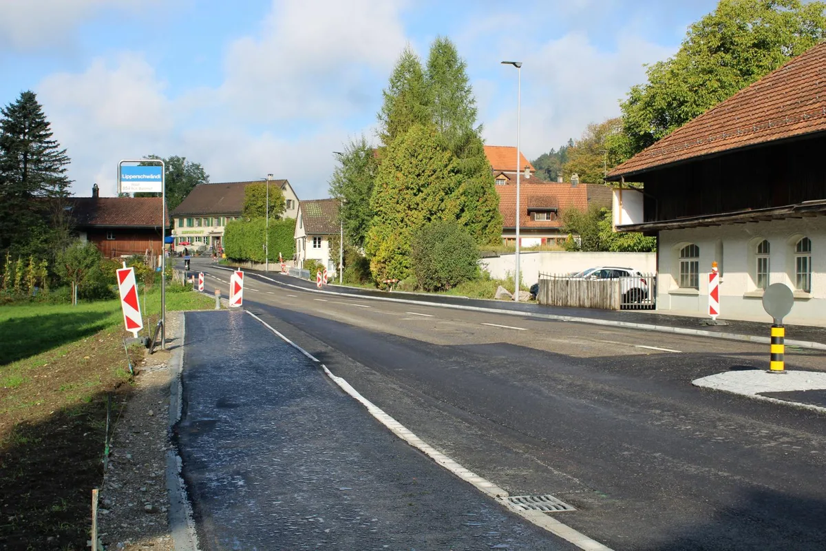 Die Arbeiten bei der Bushaltestelle Lipperschwendi neigen sich dem Ende zu., Für den Einbau des Deckbelags muss die Strasse gesperrt werden.