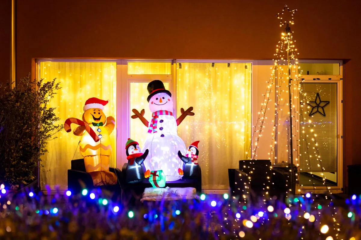 Weihnachtsbeleuchtung Uster, ein Schneemann und Lichter vor einem Haus.