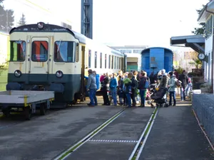 p1140869_preview Die Plauschfahrten zum Ritterhaus und wieder zurück sind sehr beliebt. Eingestiegen wird hier am alten Bahnhof Wolfhausen., An der Lochrütistrasse führend die Gleise zwischen Wohnhäusern und Industrie hindurch., Idyllische Strecke: Der Triebwagen vor dem Rittrerhaus Bubikon, wo die Gleise enden., Zinkereistrasse Wolfhausen: Hier überqueren die Schienen die Strasse.