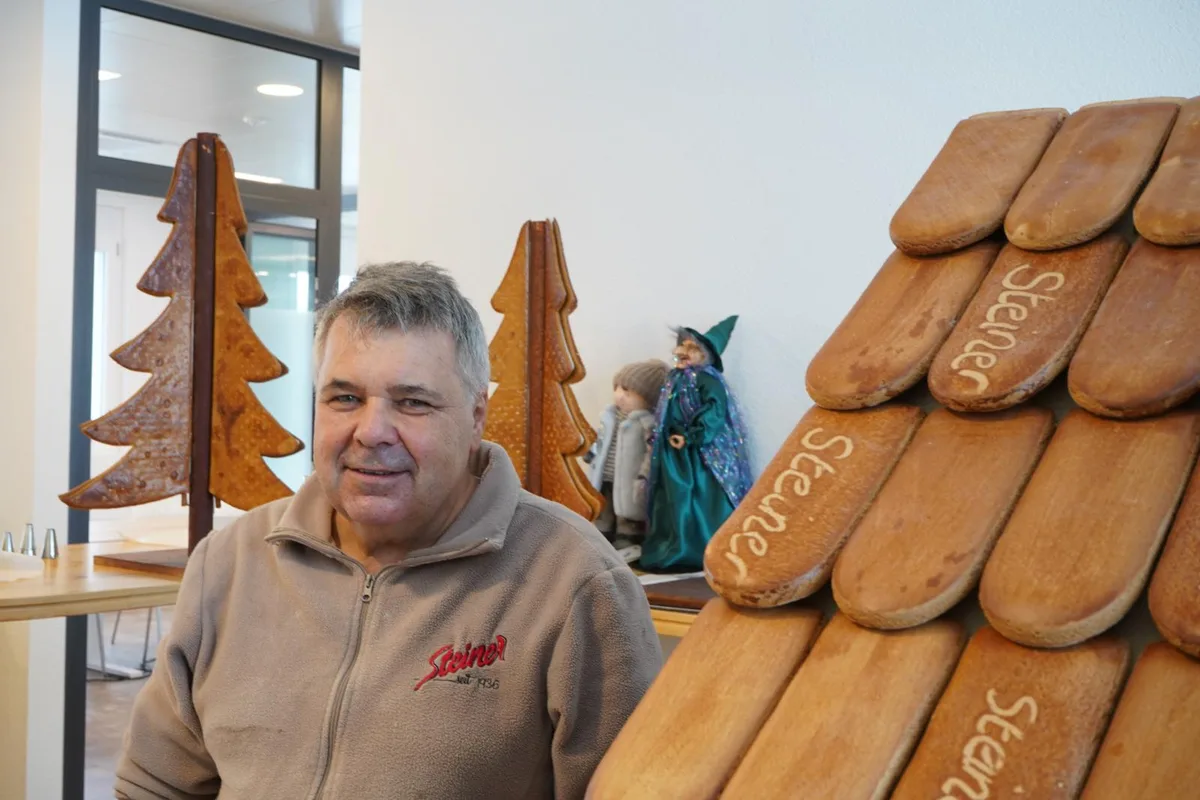 Auf der linken Seite steht der 64-jährige Bäcker Fritz Mahler, der für den Steiner Beck ein rund 1,60 Meter hohes Lebkuchenhaus gebacken hat. 
