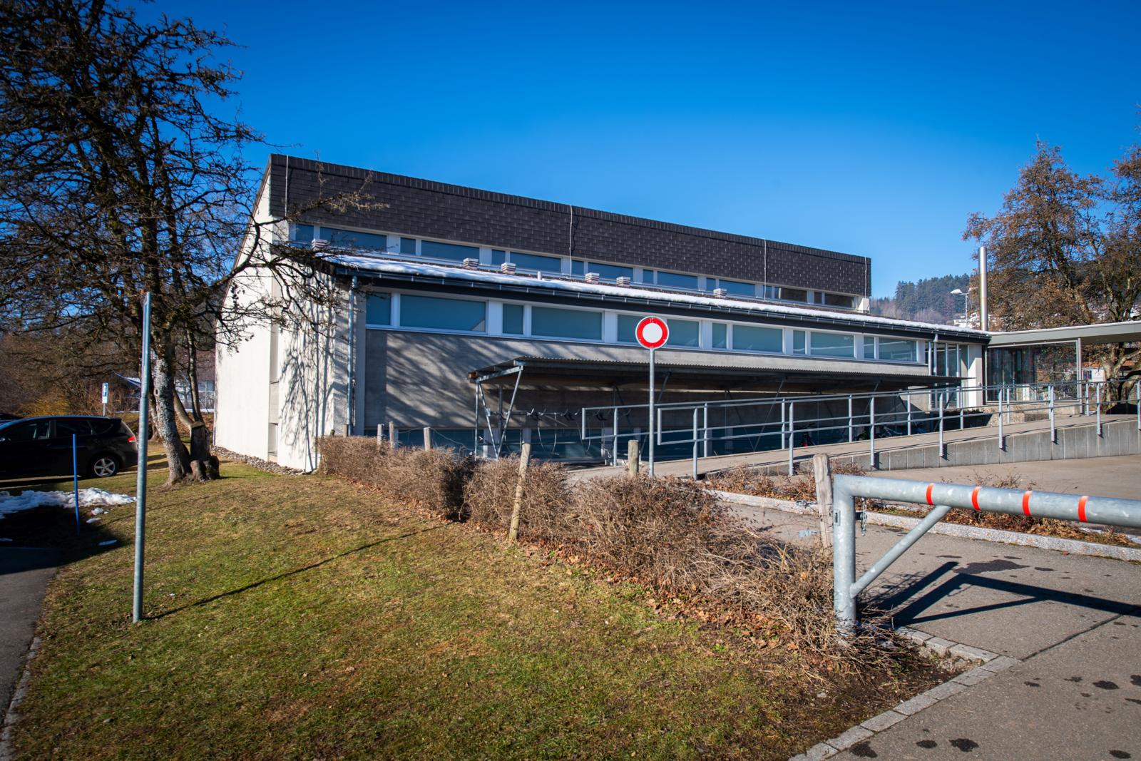 Auf dem Foto ist die alte Turnhalle in Adetswil zu sehen. 