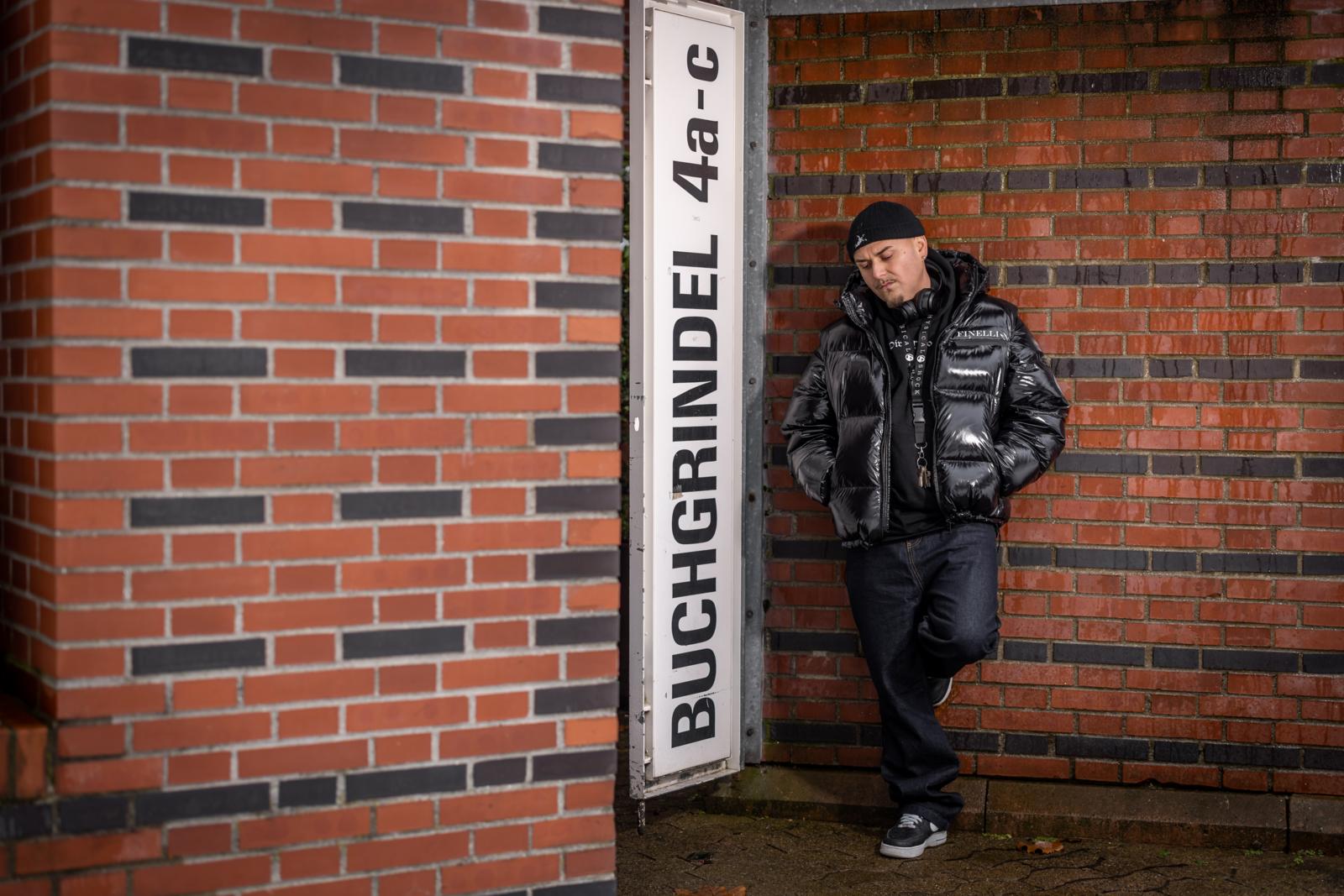Der Rapper EAZ posiert an der roten Wand in einer Siedlung an der Buchgrindelstrasse.