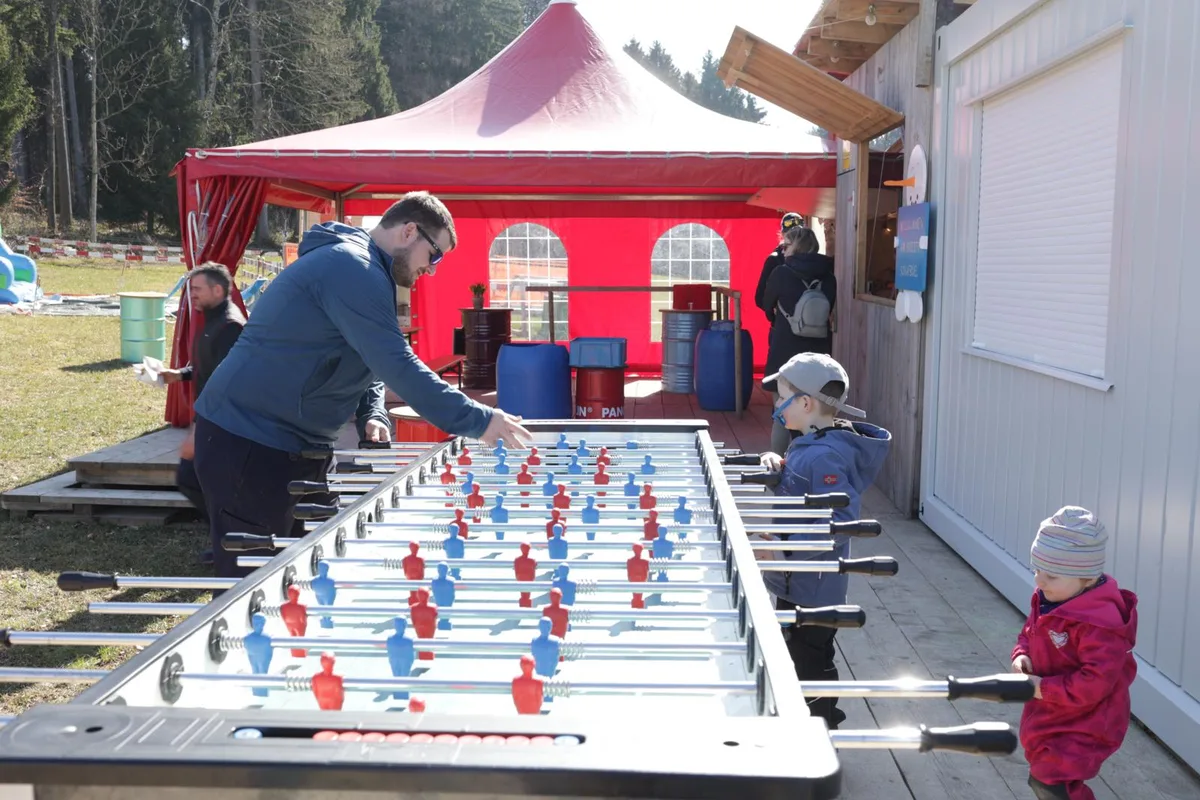 https-zueriost-ch-sites-default-files-elvis-media-2022-03-skilift-schafbueel-saisonabschluss-2_preview-jpg Ohne Schnee bietet der Töggelikasten am Saisonabschluss des Skilifts Schafbüel gute Unterhaltung., Beim Verpflegungscontainer sorgte sich das Team um das leibliche Wohl der Besucher. , Die Willkommenstafel beim Abschlussfest neben dem Verpflegungscenter., Einige Familien mit Hunden waren auch vor Ort., Die Helfer waren stets beschäftigt., Die Küchenmannschaft hatte alle Hände voll zu tun., Das Kassenhaus steht aktuell leer., Der alte Präsident Urs Christinger (links) stosst mit seinem Nachfolger Patrick Schmied auf eine gelungene Saison an., Ans Skifahren war am Saisonabschluss nicht zu denken.