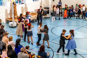 https-zueriost-ch-sites-default-files-elvis-media-2022-04-dancing-classroom-turbenthal-schulhaus-risi-gu-07_preview-jpg Beim Abschlussball in der Turnhalle zeigen die Primarschulkinder ihre Tanzkünste., Höchste Konzentration: Die richtige Kombination der Schritte ist gar nicht so einfach., Etwas lockerer sieht dies beim Line Dance aus., Klassenlehrpersonen Sócrates Benjamim und Ayline Metzger mit Tanzlehrerin Stefanie Forgione und Schulleiter Kaspar Schüpbach. , Zur Auflockerung gibt es nach jedem Tanz ein kurzes Zwischenprogramm.