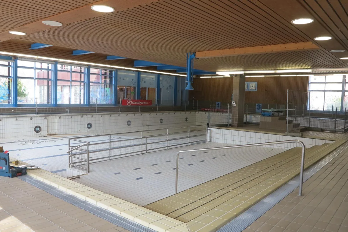 https-zueriost-ch-sites-default-files-elvis-media-2022-05-tag-der-offenen-tuere-hallenbad-bauma-bre-6-jpg_preview-jpg Leeres Schwimmbecken: Das Hallenbad Bauma wird derzeit saniert., Wie bei der Ausgrabung eines altrömischen Bades: In den Garderoben fanden sich vier Lagen Plättli übereinander., Da hier Asbeststaub freigesetzt werden kann, arbeiten die Experten in abgegrenzten Zonen unter Unterdruck.