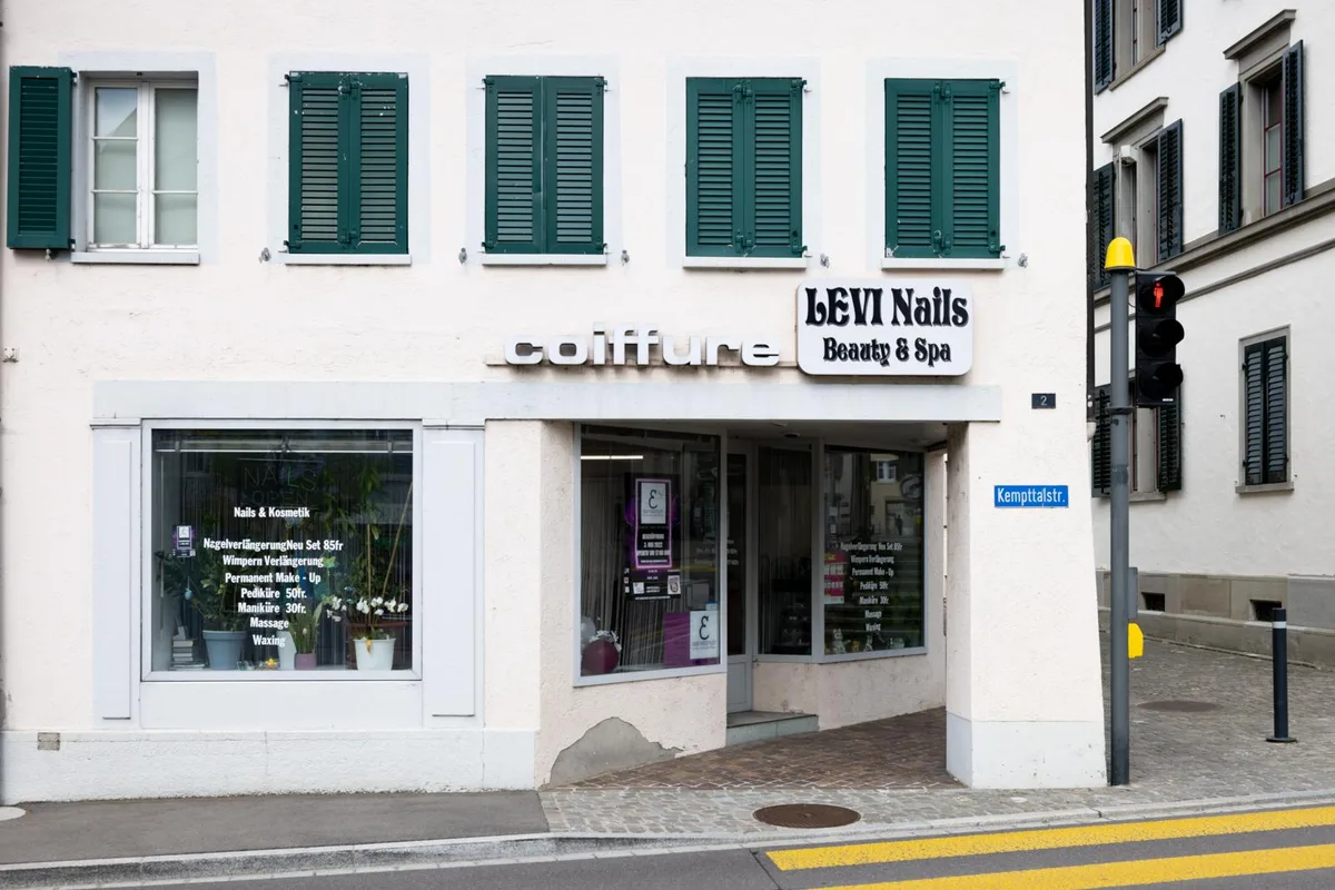 Hauseingang mit Beschriftung von Nagelstudio und Coiffeur. 