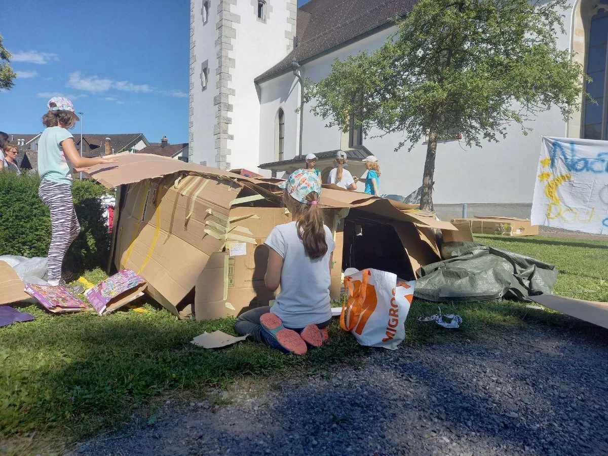 photo_5893015294610356549_y-jfif_preview Die Jugendlichen bauen sich ihre Hütten., Auf dem Platz vor der Kirche verbringen sie eine Nacht im Freien., Am Nachmittag haben die Teilnehmer Kaffee und Kuchen verkauft – und sammelten so Spenden.