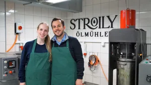 stroily-olmuehle-bauma-aline-benoit-und-chistoph-grammont_preview Die beiden Ölmüller: Aline Benoit und Christoph Grammont haben ihre eigene Firma gegründet., Ihre Maschinen haben sie entweder gebraucht gekauft oder selber bauen lassen. Beispielsweise den Röster (hinten links). , Trotz der Maschinen steckt hinter ihrem Produkten viel Handarbeit.