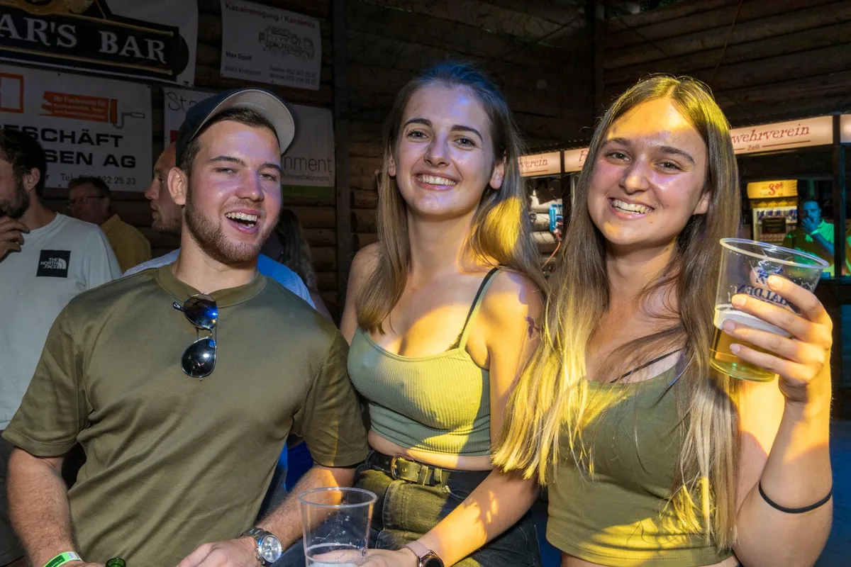 sommernachtsfest-rikon-gu-02_preview Strahlende Gesichter: Beim Tösstaler Sommernachtsfest waren alle glücklich., Ob es am Fest oder dem ausgeschenkten Alkohol lag, wissen wir nicht., Rund 3000 Gäste besuchten den Anlass in Rikon..., ... und verwandelten den Tobelhof in eine Riesenparty-Location., Für Live-Musik war gesorgt., Die Bühne wurde gerockt., Letztlich strahlten alle Besucherinnen ..., ... und Besucher., Gefeiert wurde bis in die frühen Morgenstunden., Die Tanzfläche war berstend voll., Sonnenschutz war auch abends wichtig., Und natürlich die passenden Getränke.