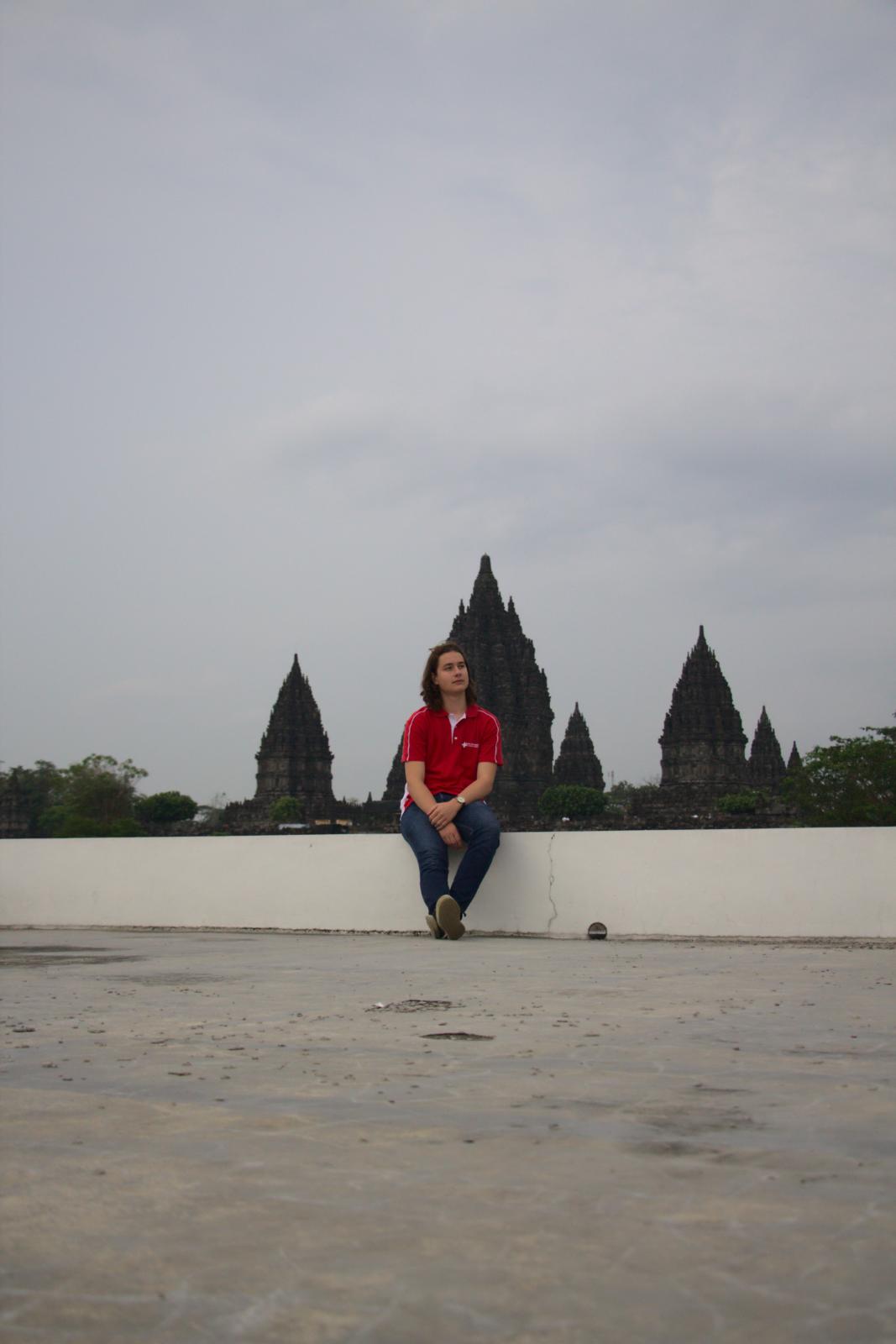 Josia John, Effretiker Teilnehmer an der Informatik-Olympiade 2022 in Yogyakarta, posiert vor einem Tempel.