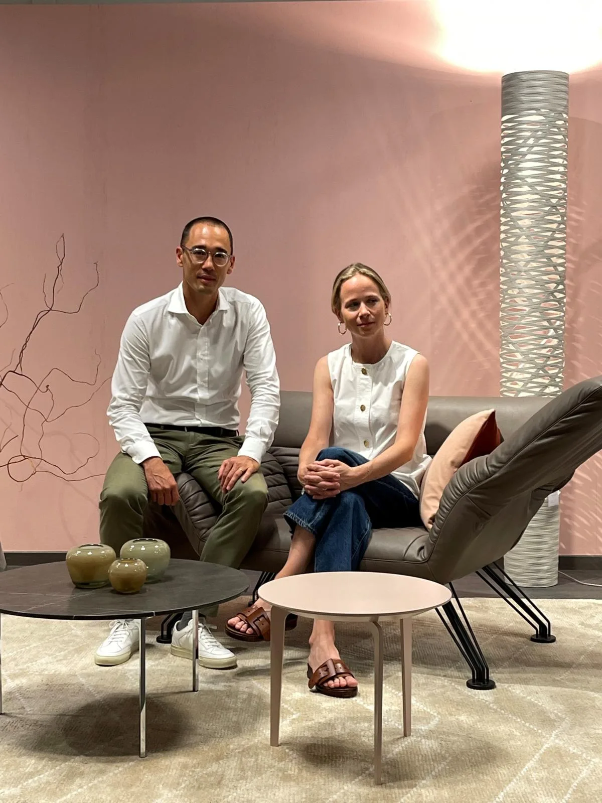 Als junge Geschäftsleitung sehen Kay Egger und Andrea Seiler mehr unternehmerisches Potenzial in der Planung von Innenausbauten. Zwei Menschen sitzen in einer Möbelausstellung auf einer Couch und blicken in die Kamera.