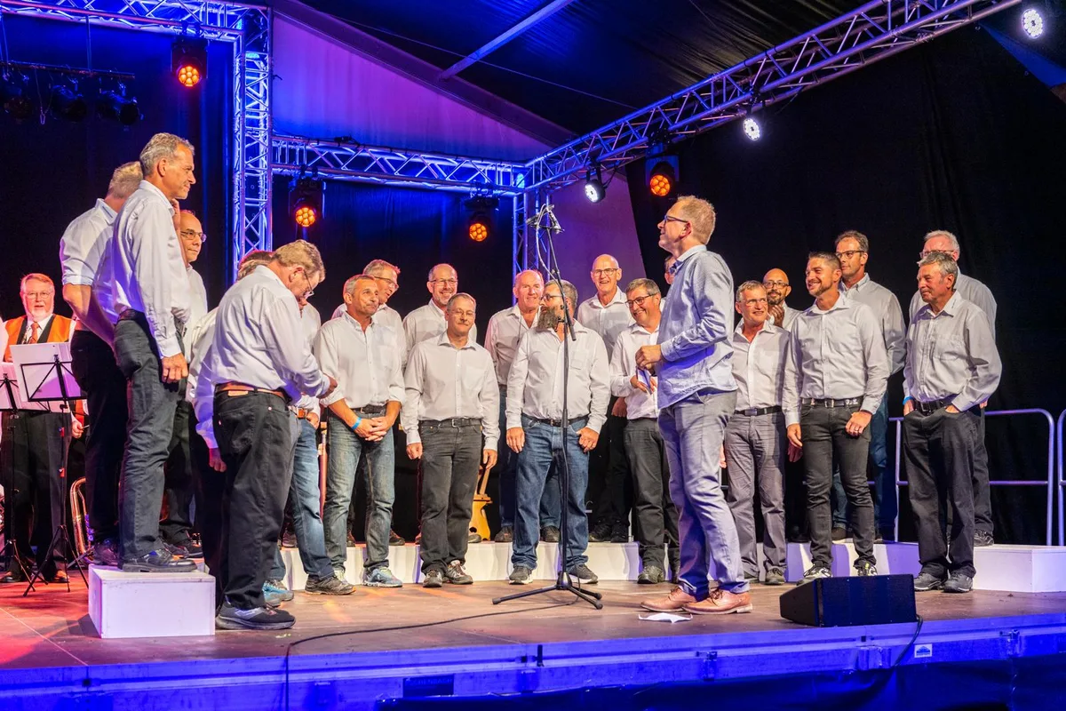1599-15_preview Der Männerchor gab beim Jubiläumsfest sein Können zum Besten., Auch die Die Neubrunner Schulkinder zogen das Publikum in ihren Bann., Nicht fehlen durfte der Auftritt der Theatergruppe., Gemeindepräsident René Gubler gratulierte dem Jubilar.