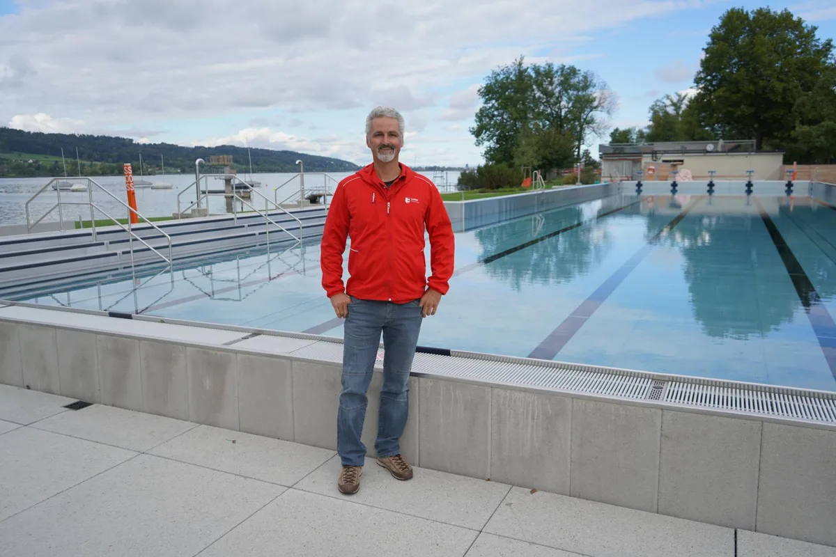 Mann in roter Jacke vor einem 50-Meter Schwimmbecken in der Seebadi Uster.