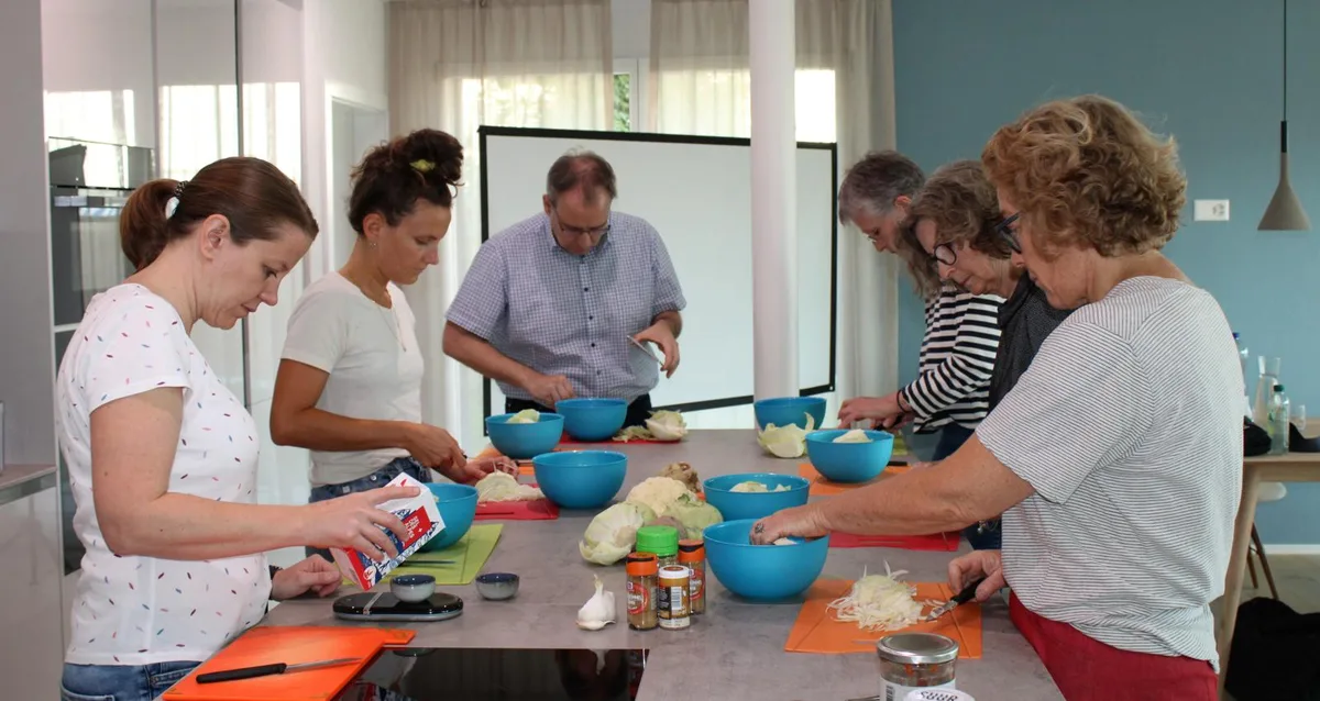 fermentierkurs-duebendorf-sauerkraut_preview Um Curtido herzustellen, müssen die Kursteilnehmer Kohl schneiden. Vorne links steht Kursleiterin Franziska Wick., Franziska Wick zeigt den Teilnehmenden, wie man verschiedene Gemüsesorten fermentiert. Im Glas befinden sich Tomaten.