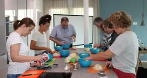 fermentierkurs-duebendorf-sauerkraut_preview Um Curtido herzustellen, müssen die Kursteilnehmer Kohl schneiden. Vorne links steht Kursleiterin Franziska Wick., Franziska Wick zeigt den Teilnehmenden, wie man verschiedene Gemüsesorten fermentiert. Im Glas befinden sich Tomaten.