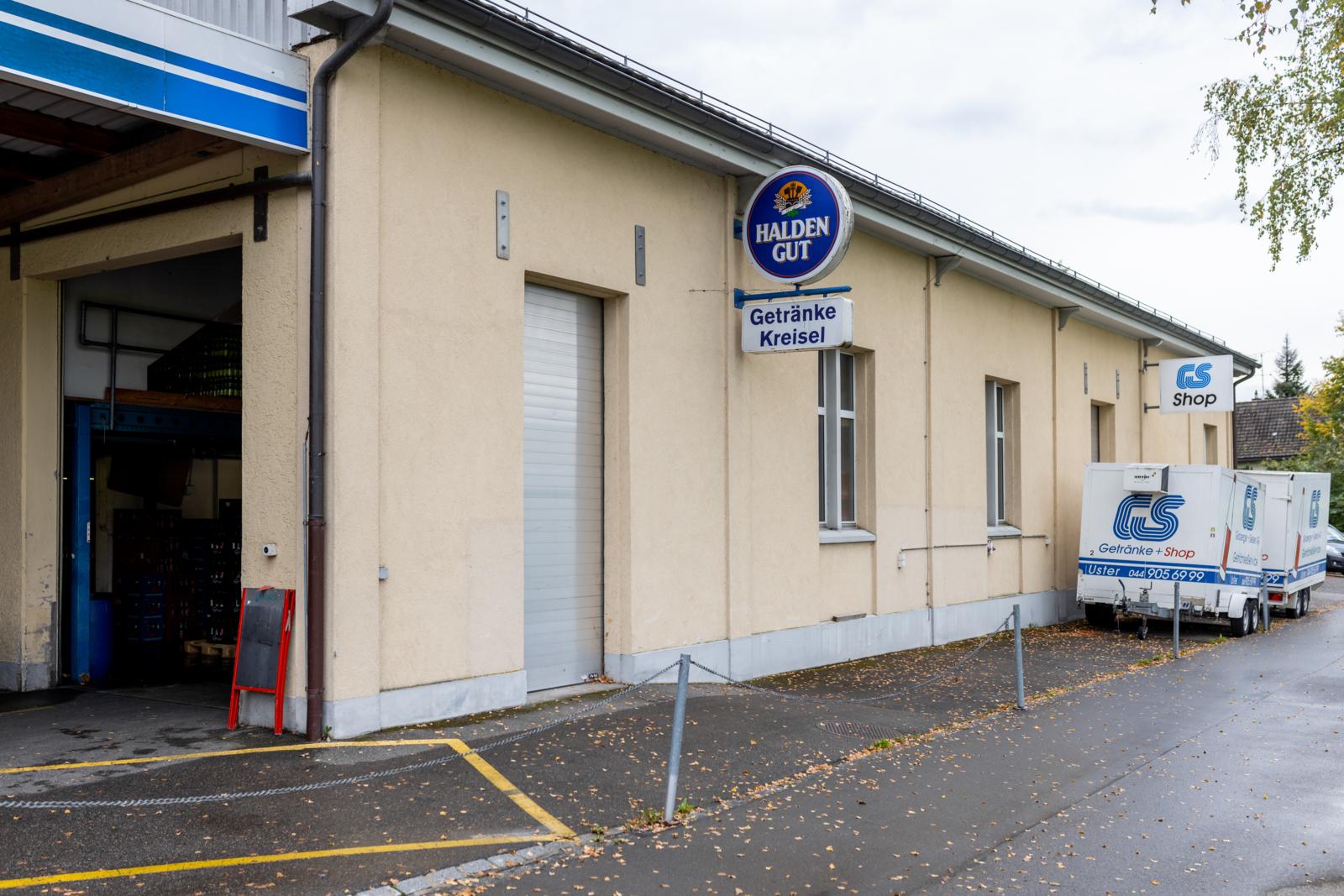 Vor einem Lagergebäude stehen zwei Kühlwagen-Anhänger.