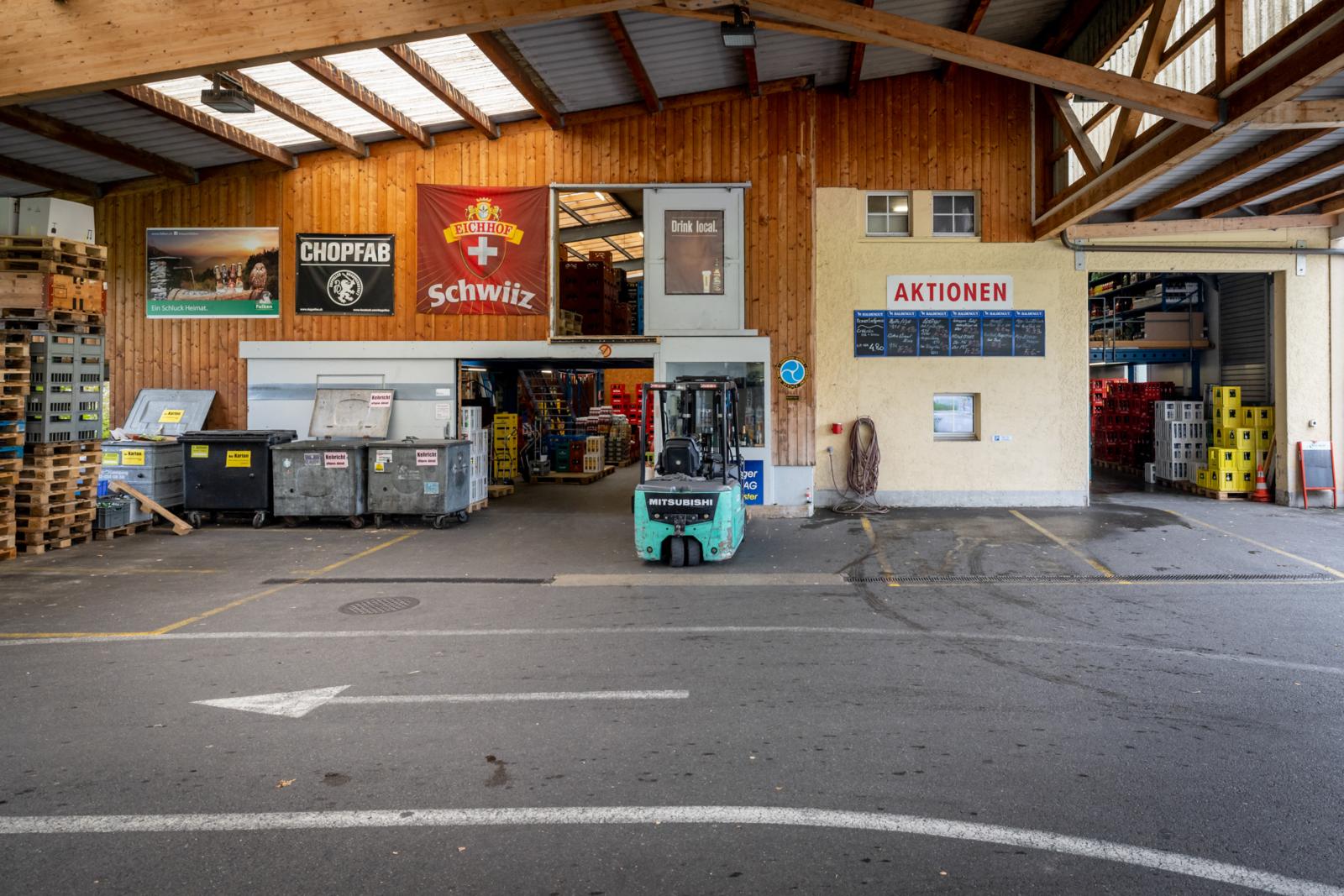 In einer Lagerhalle steht ein mintgrüner Gabelstapler.