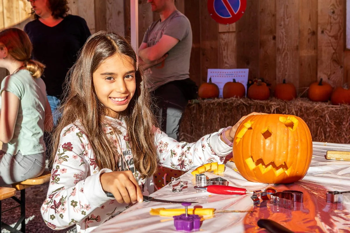 Das Kürbisfest in Wila war kreativ, gemütlich  und vor allem sommerlich warm., Zahlreiche Kinder nahmen an dem Anlass teil., Treffpunkt war das Schützenhaus., Bei sommerlichen Temperaturen wurden zahlreiche Kürbisse verziert., Eltern unterstützten ihre Kinder bei den Schnitzarbeiten., Die Stimmung war ausgelassen., Gruselige Fratzen: Schliesslich ist bald Halloween., Auch für das leibliche Wohl war am Samstag gesorgt., Ein Team des Verkehrsvereins Wila war um die Verpflegung besorgt., So konnten die Anwesenden mit Bier und Wein ihre Kehlen benetzen., Der Herbst zeigte sich am Samstag von seiner schönsten Seite., Entsprechend viele Wilemerinnen und Wilemer liessen den Tag bei einem kühlen Getränk ausklingen., Am Ende wurden die geschnitzten Meisterwerke mit nach Hause genommen.