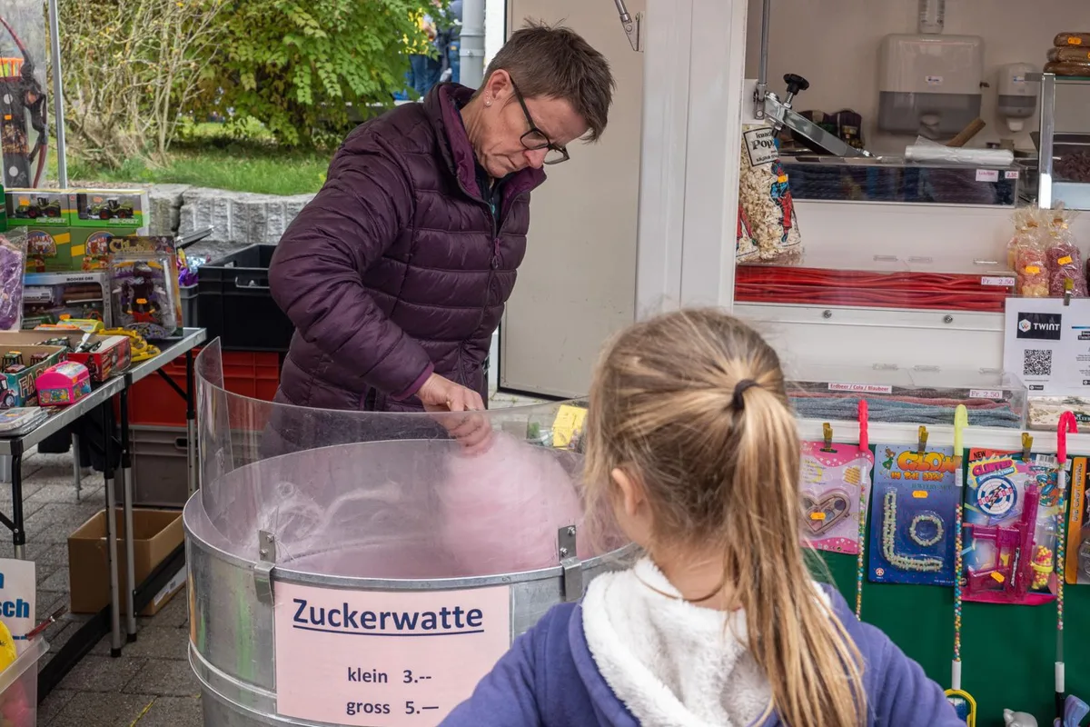 31102022-turbenthal-herbstmarkt-agy-5_preview Nicht fehlen durfte am Herbstmarkt die Zuckerwatte., Dieser fand traditionsgemäss im Zentrum von Turbenthal statt., Die Stände hatten Verschiedenes zu bieten, wie zum Beispiel kulinarische Spezialitäten …, … oder Geschicklichkeitsspiele., Während die Erwachsenen die Auslagen begutachteten, vergnügten sich die Kinder auf dem Rummelplatz., Besonders beliebt war am Mittag der Stand der Dorfmetzgerei Brunner. Die Besuchenden standen Schlange für eine Wurst., Auch Marktchef Ernst Näf (links) mischte sich unter die Markttreibenden.
