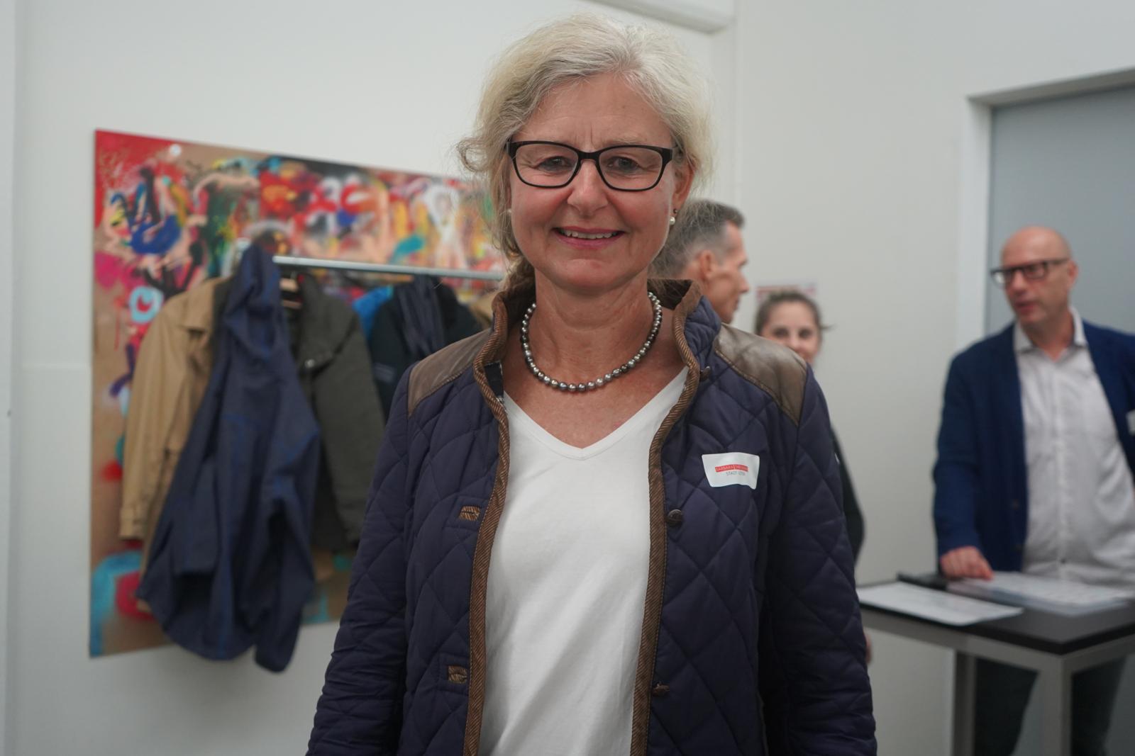 Eine Frau vor einem Bild.