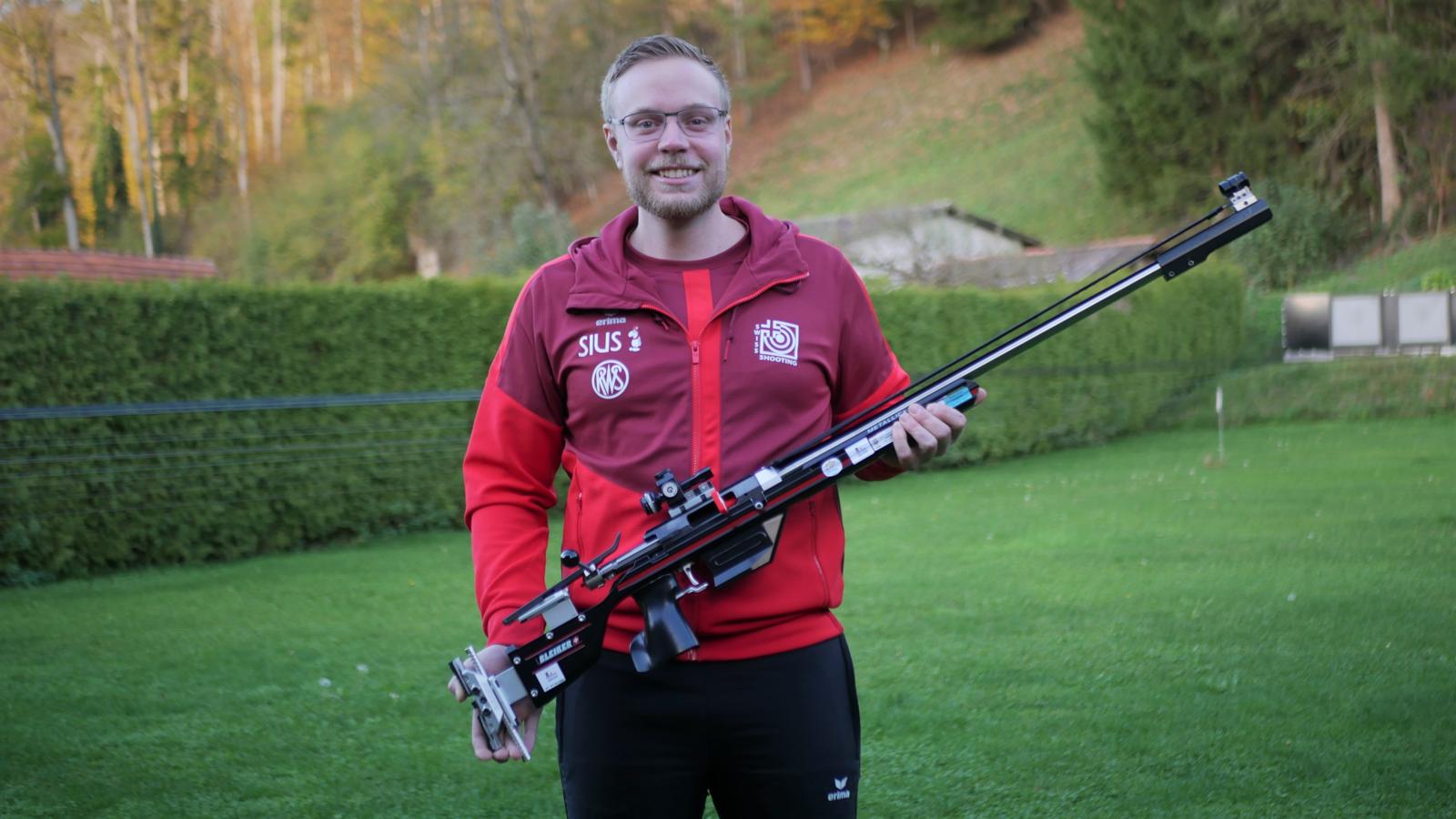Man sieht einen Schützen in seiner Turnierkleidung mit einem Sportgewehr in den Händen.