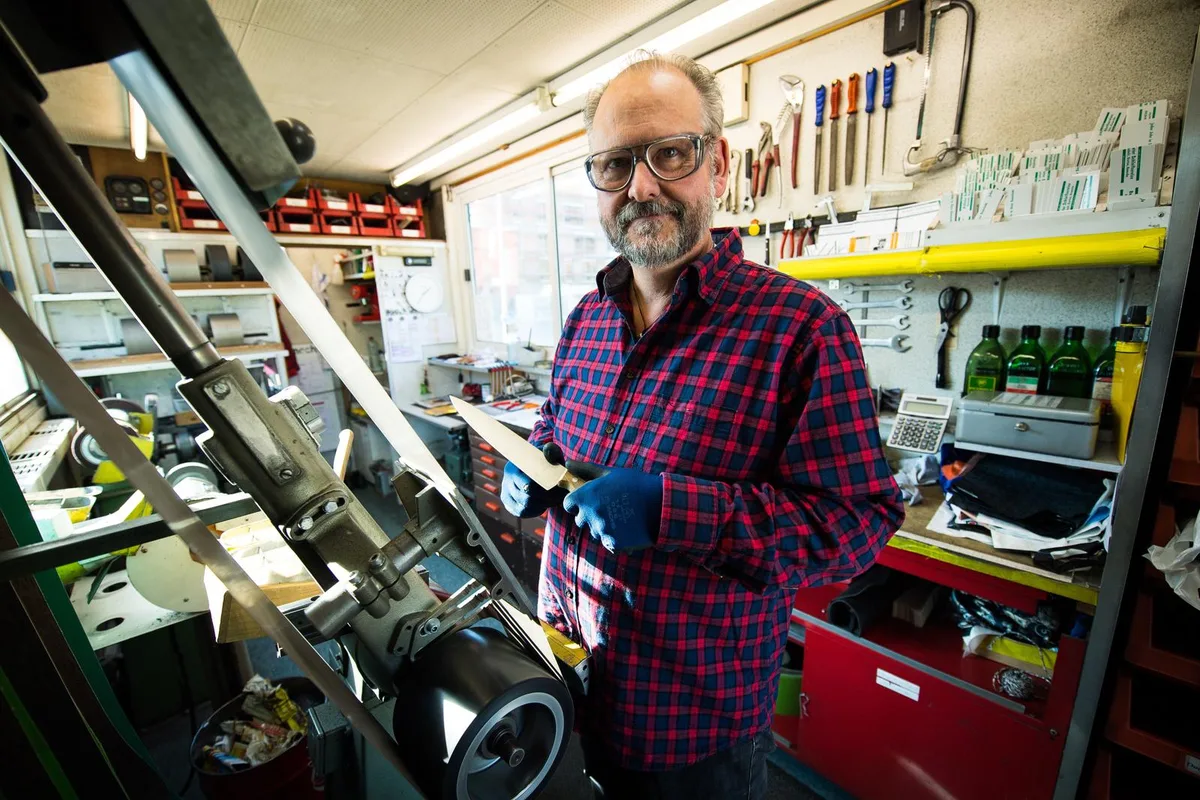 egg_01112016_messerschleifer_sbo_4_0 Carl Meyer am Schleifband: Die Handschuhe trägt er nicht wegen der scharfen Klingen, sondern damit ihm das Messer nicht aus den Fingern rutscht und quer durch den Werkstattwagen fliegt. «Das wäre nicht so gut», findet er. (Bild: Seraina Boner), Geschnitten hat sich Meyer zum Glück erst einmal. (Bild: Seraina Boner)