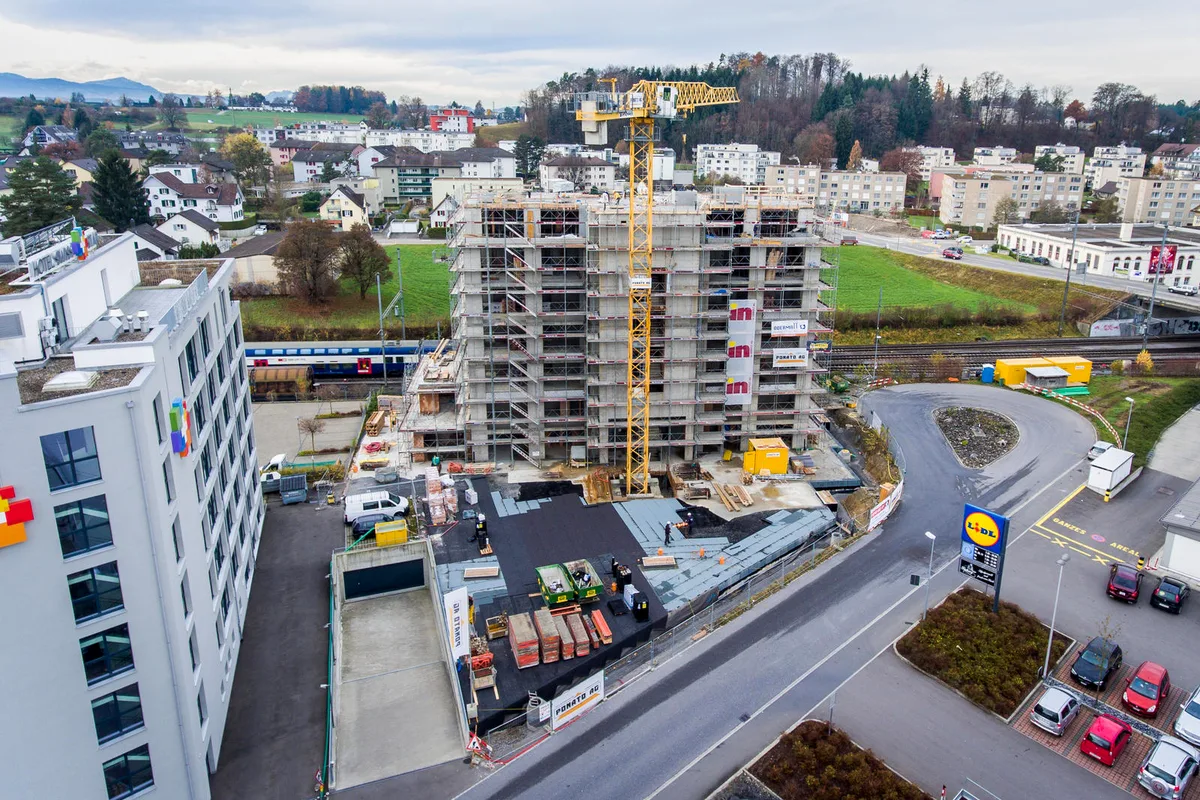 hinwil_24112016_baustelle_crm_1 Der Neubau hinter dem «Swiss Star». (Bild: Christian Merz), Das Gebäude hat dieselben Dimensionen wie das Hotel, ist aber keins. (Bild: Christian Merz), Zwei markante Gebäude: Der Blick von der Bahnlinie her. (Bild: Christian Merz), Das Hotel, das neue Bildungszentrum und der Mehrzwecksaal, im Bild ganz links, sollen sich gegenseitig befruchten. (Bild: Christian Merz), Und so soll der Neubau aussehen. (Visualisierung: zvg)