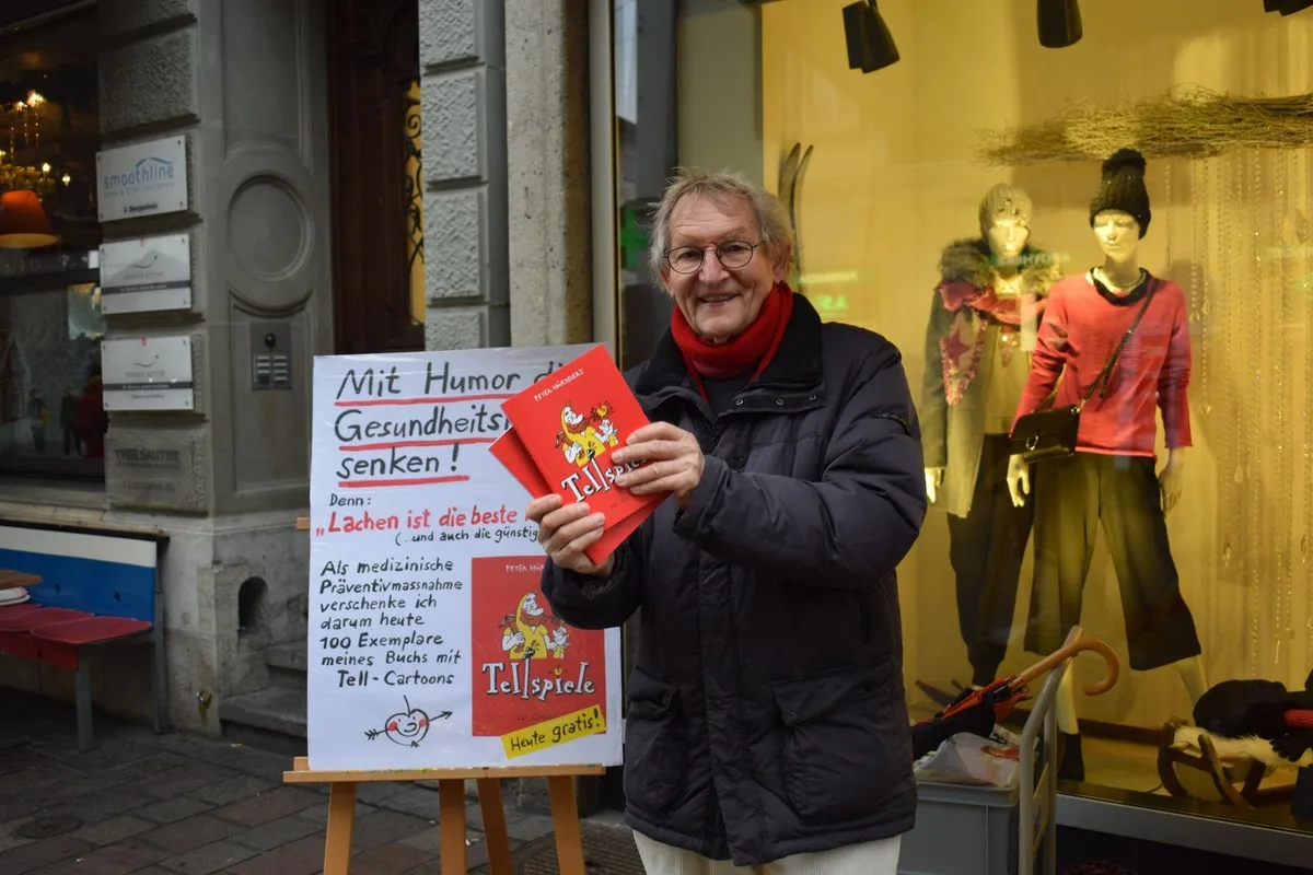 dsc_0324 Peter Hürzeler mit zwei Exemplaren von «Tellspiele».
(Bild: Talina Steinmetz) , Bei seiner Verteilaktion in der Marktgasse waren viele Passanten zuerst skeptisch.
(Bild: Talina Steinmetz) , Nachdem diese Skepsis überwunden war, wurde das Buch dankend angenommen.
(Bild: Talina Steinmetz) , Wie geplant konnte Peter Hürzeler den Passanten ein Lachen ins Gesicht zaubern.
(Bild: Talina Steinmetz) , 100 Exemplare wurden verteilt.
(Bild: Talina Steinmetz) , Der Winterthurer freute sich mit jedem einzelnen und beantwortete gerne Fragen zu seiner Karriere.
(Bild: Talina Steinmetz) , Familien, Paare, Einzelpersonen: Alle freuten sich über das Buch.
(Bild: Talina Steinmetz) , Die Motivation hinter der Aktion: «Mit Humor die Gesundheitskosten senken».
(Bild: Talina Steinmetz) , Ein Buch, dass zusammen bringt.
(Bild: Talina Steinmetz) , Peter Hürzeler hat in 43 Jahren mehr als 2200 Cartoons gezeichnet.
(Bild: Talina Steinmetz) , Auch seine Tochter Cathy half mit bei der Verteilaktion.
(Bild: Talina Steinmetz) , Ein Geschenk auf Winterthurer Strassen: Das Buch «Tellspiele».
(Bild: Talina Steinmetz) , Aus 2200 Cartoons hat der Winterthurer die besten 261 ausgewählt.
(Bild: Talina Steinmetz) , Kiste um Kiste konnten die Bücher verteilt werden.
(Bild: Talina Steinmetz)