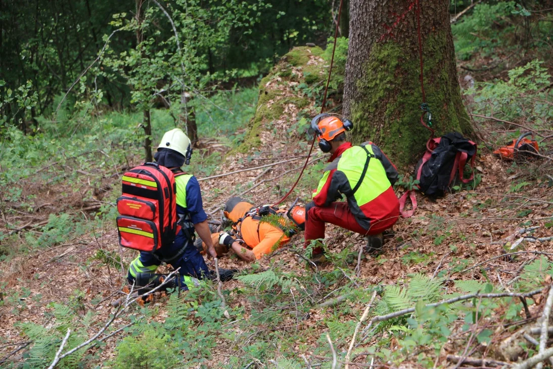 o_img_4377 Ein Angehöriger der Feuerwehr Fischenthal (links) ist zum «verletzten» Forstwart hinuntergestiegen und übernimmt mit einem Kollegen des «Verunglückten» die Erstbetreuung. (Fotos:Ernst Hilfiker), Ein Bild, das die Dimensionen und eines der Hauptprobleme zeigt: Der «Verletzte» im Steilhang ist kaum zu erkennen; der Zugang zu ihm schwierig., Bis die Rettungskrägte eintreffen, wird der «Verletzte» von einem Forstwarkollegen betreut., Erste Angehörige der Feuerwehr Fischenthal sind eingetroffen und seilen sich zur «Unfallstelle» ab., Nun ist auch ein Team des Rettungsdienstes Regio 144 angekommen. Im Vordergrund: eine sogenannte Schleifkorbtrage, in welcher man Verletzte in unwegsamem Gelände bergen kann., Angehörige der Feuerwehr und des Rettungsdienstes heben den «Verletzten» vorsichtig in die Schleifkorbtrage., An Seilen gesichert, tragen die Rettungskräfte den «Verletzten» den Hang hinauf zu einem Wanderweg. , Danach kann der «Patient» zum Rettungswagen getragen und ins Spital gefahren werden.