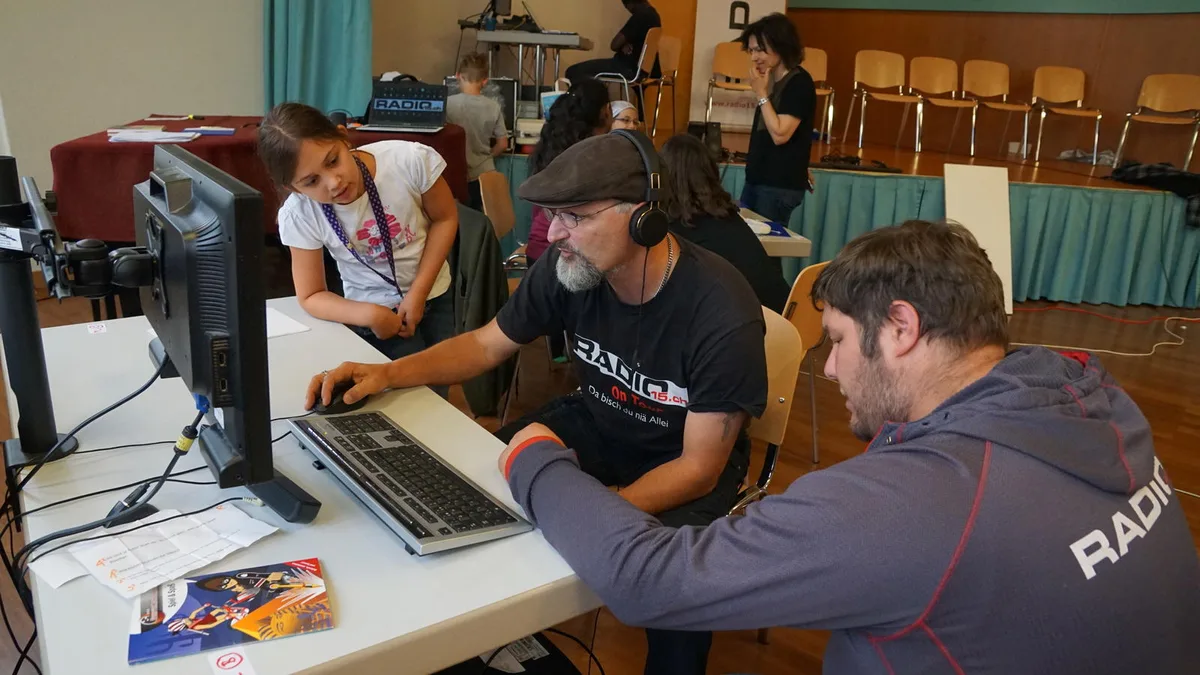 dsc00571 Mathias Betschart (Mitte) und Stefan Fischer (rechts) helfen aus. , Nach einer Woche geht das Schneiden von Beiträgen schon fast alleine. , Noah in Action: Ist die Moderation mal nicht perfekt, stört das niemanden., Nico muss sich erst an den Klang seiner eigenen Stimme gewöhnen., Ein paar Einweisungen, und schon haben es die Kinder im Griff., Das passiert, wenn man mit dem Fotoapparat auf dem Pausenplatz rumläuft., Ein Ereignis: Die Gschwader-Hitparade auf dem Pausenplatz.