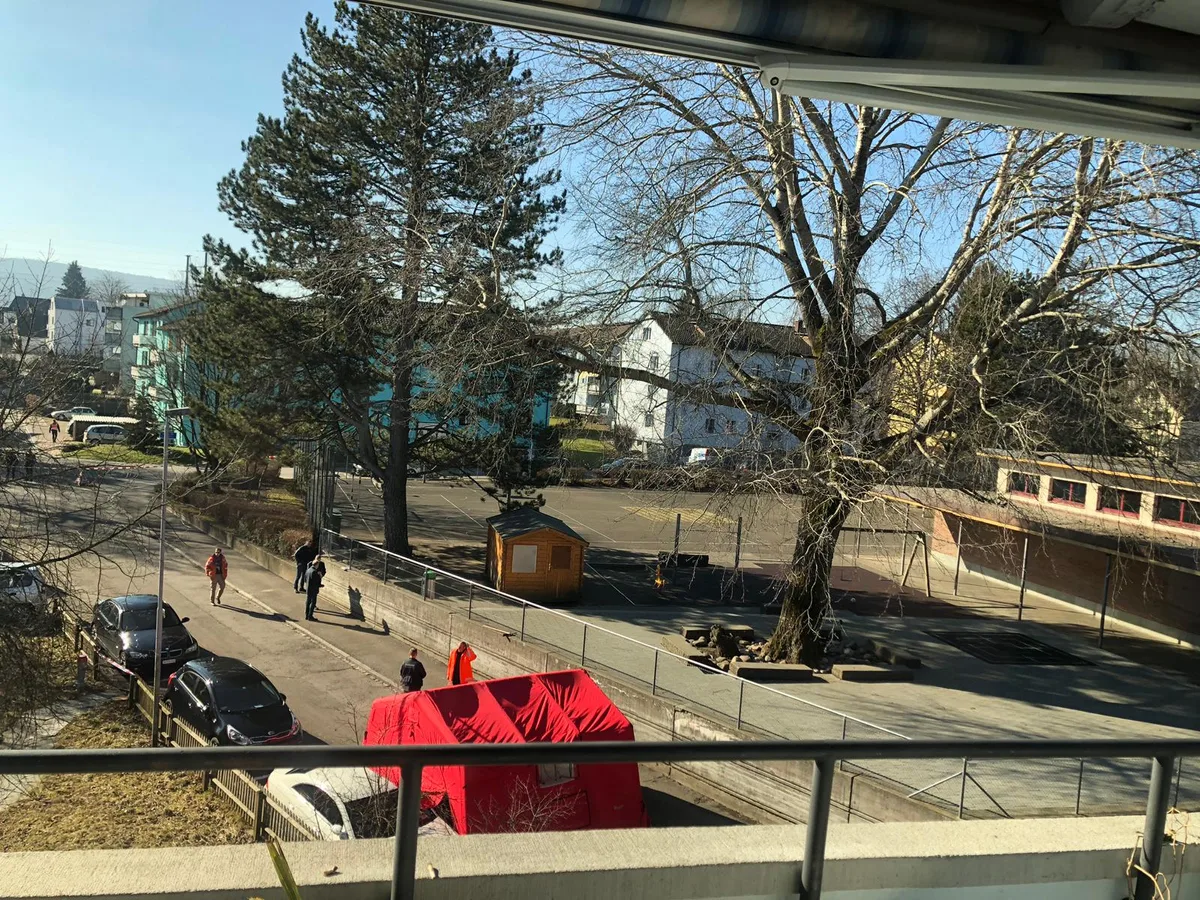whatsapp_image_2019-02-13_at_12-32-55 Vom Balkon eines Anwohners aus: Die Polizei sichert die Spuren., Die Kantonspolizei Zürich war mit einem Grossaufgebot vor Ort. , Hier wurde die 29-jährige Tote gefunden: ein Parkplatz unweit des Schulhaus Flugfeld in Dübendorf., Das Auto, unter dem die Leiche lag, wird mit einem gelben Lastwagen abgeschleppt., Die Polizei geht von einem Verbrechen aus., Der Anwohner sagt, die Frau hätte unter einem Auto gelegen., Die Tote wurde direkt neben dem Schulhaus in der Immenhauserstrasse gefunden.