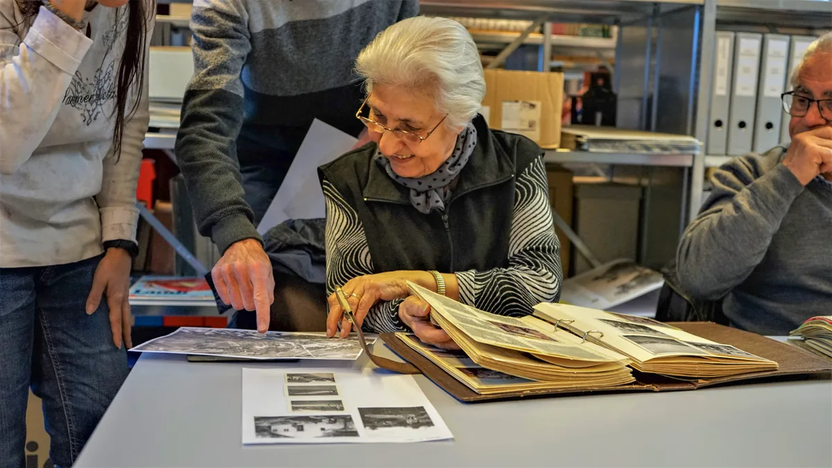 dsc09151 Sie kündigte bei Textima, nachdem eine Polizeirazzia stattfand., Kyriaki Londis kam 1961 als Gastarbeiterin zur Textima AG in Hittnau., Nach mehr als 50 Jahren kehrte sie, zusammen mit anderen Gastarbeitern von damals, an den ehemaligen Arbeitsort zurück., Zusammen mit ihrer Tochter Vicky forstete sie diverse Fotoalben von damals durch., Londi verliess ihre Heimat in Nordgriechenland 1959 infolge politischer Unruhen.