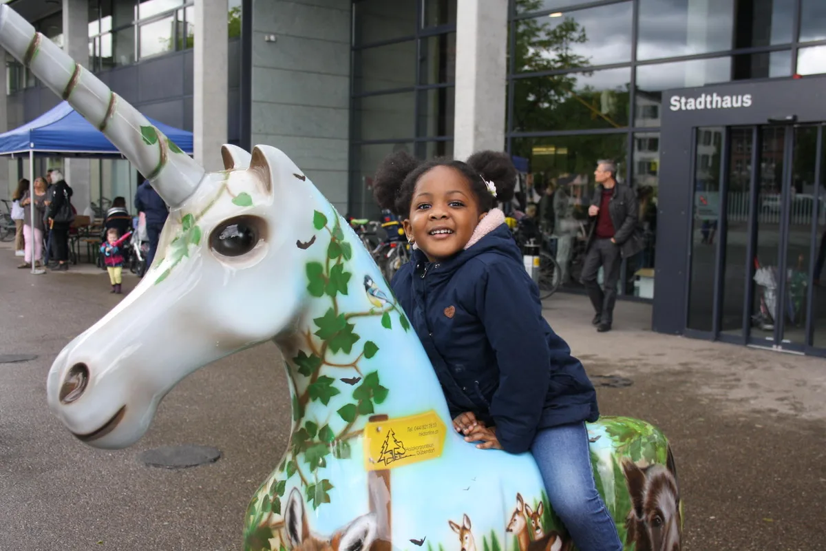 img_1882_0 Die kleine Kenza reitet das Einhorn der Holzkorporation,, Noch Kunst oder schon Werbeplakat?, Das Einhorn der Oberen Mühle., Einhorn mit schnittigem Renn-Design. Man beachte den Stossdämpfer., Wie die meisten anderen ist auch dieses Einhorn nicht gerade in Tarnfarben gehalten., Airbrush-..., --- und Schwamm-Technik., Das Einhorn wird zum Brunnen., Wer hat das hier gemacht? Logisch, der Samariterverein., Glattwerk-Einhorn mit Leni-Riefenstahl-Pose., Einhorn im Smarties-Look. Schmeckt aber nach nichts (der Fotograf hats ausprobiert)., Dieses hier steht vor dem ReZ und hat mit Abstand die schönsten Augen, seufz., Das steht schon lange hier: Einhorn-Plastik auf dem Lindenplatz., Dieses Einhorn hat eine eigene Dusche, und glänzt einfach wunderschön., Auch eine Variante: Einhorn mit Rollen., Keine Überraschung. Blumen-Einhorn vor Blumenladen., Das hier haben die Mitarbeiter der ZKB gemacht., Und das hier haben nicht die Mitarbeiter der UBS gemacht, sondern Kindergärtler., Interaktives Einhorn mit QR-Code auf dem Rücken. Ist das schon Tierquälerei?, Lustig, das Einhorn der Stadtpolizei ist hinter Gitter., Das einzige Einhorn, das bei dem Sauwetter nicht friert., Sieht erbärmlich aus: Ein Einhorn, dem Vandalen das Horn – dessen einzige Schwachstelle – abgerissen haben., Das hier ist der Liebling der Kinder., Mal sehen, ob es die Vandalen auch mit dem Super-Einhorn aufnehmen. , Das Werk von Rolf Knie im Stadthaus., Hier wurde es übergeben., Barbara Sturzenegger bei ihrer Dankesrede., Auch Stadtpräsident André Ingold ist feierlich gestimmt., Wer in Dübendorf etwas auf sich hält, lässt sich die Vernissage nicht entgehen., Bildhauer Bruno Eggenberger fordert die Anwesenden auf, die Einhörner zu beschützen., Bis unters Dach gefüllt: das Stadthaus Dübendorf., Sieht schwer aus, ist es aber nicht., Die Einhörner sind aus Kunststoff, der Rost hier ist nur aufgemalt., Das Einhorn des Verschönerungsvereins., Das Trojanische Einhorn ohne Horn., Bitte beachten Sie die kreative Gestaltung des Sockels., Das Aloha-Einhorn mit Pet-Blumen., Das einzige schwarze Einhorn steht vor dem Sozialamt., Das Einhorn mit der besten Platzierung., Die Feuerwehr war auch kreativ, man beachte das Schlauch-Horn., Und hier zum Abschluss das Astro-Horn beim Innovationspark.